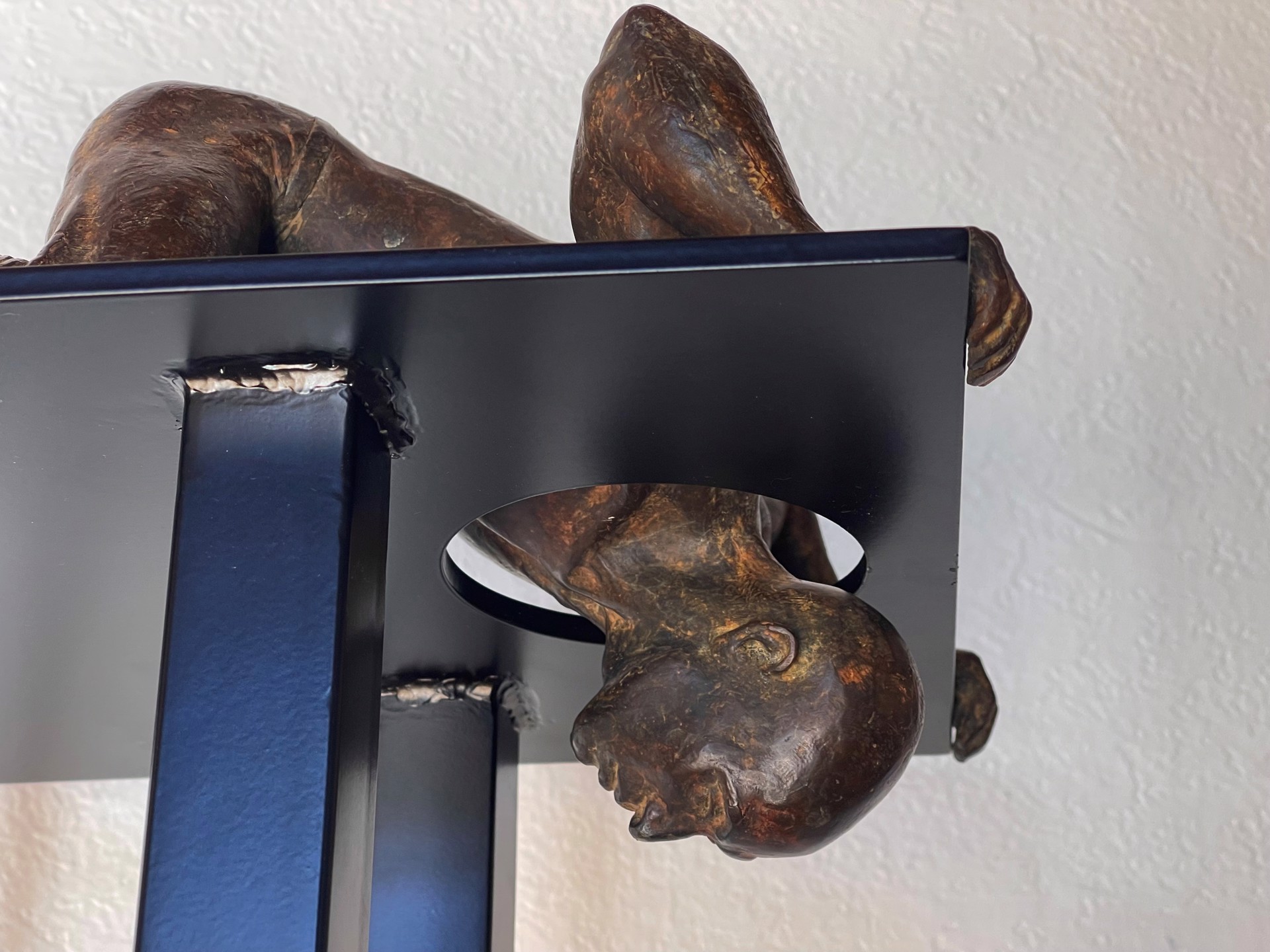 A bronze sculpture of a woman laying on a pedestal.