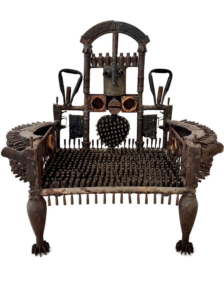 A dark, industrial chair constructed from repurposed mechanical and military parts.