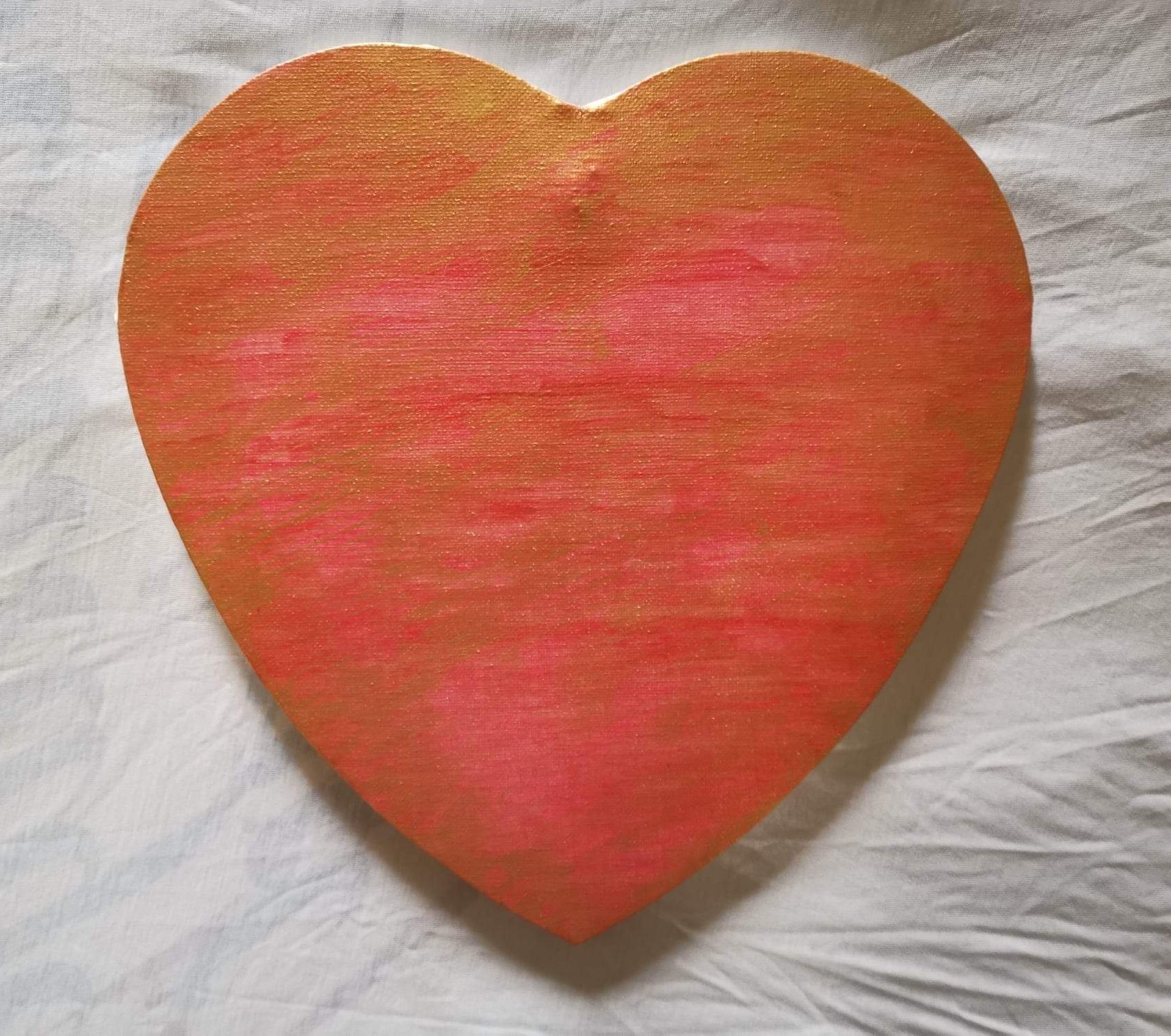A red heart painted on a white sheet of paper.
