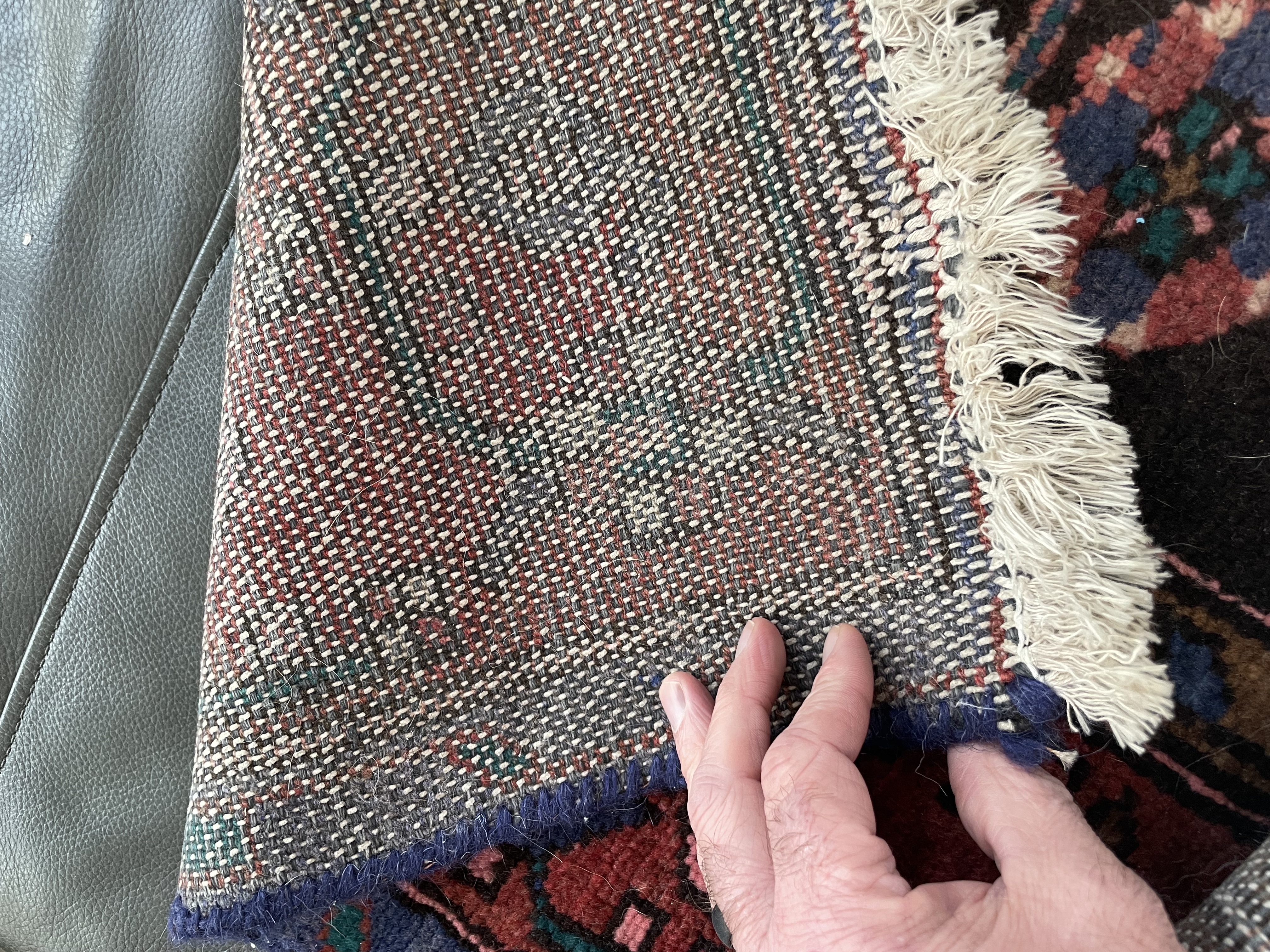 A traditional runner rug with a central medallion design, featuring geometric patterns and a rich palette of reds, purples, and blues.