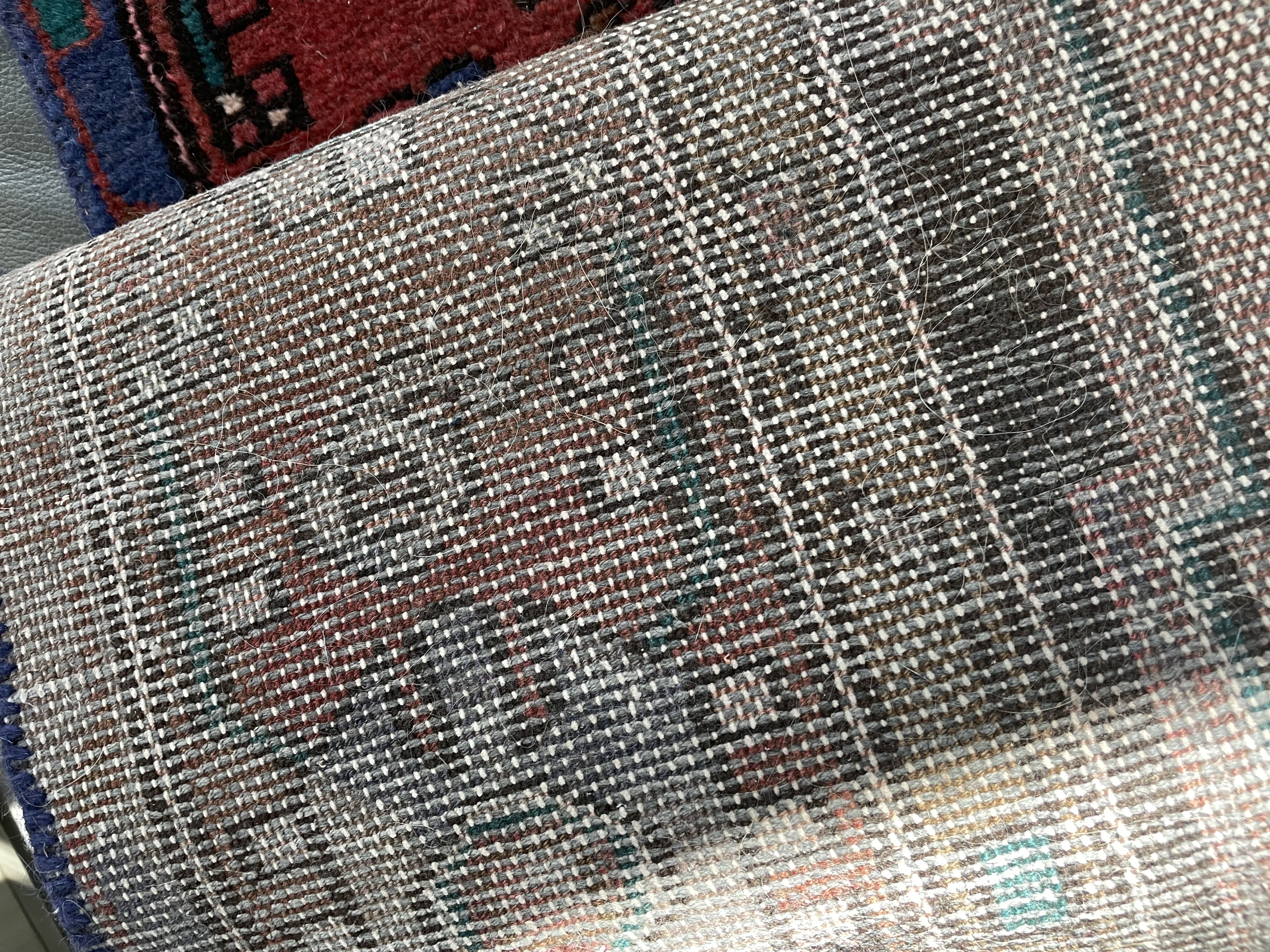 A traditional runner rug with a central medallion design, featuring geometric patterns and a rich palette of reds, purples, and blues.
