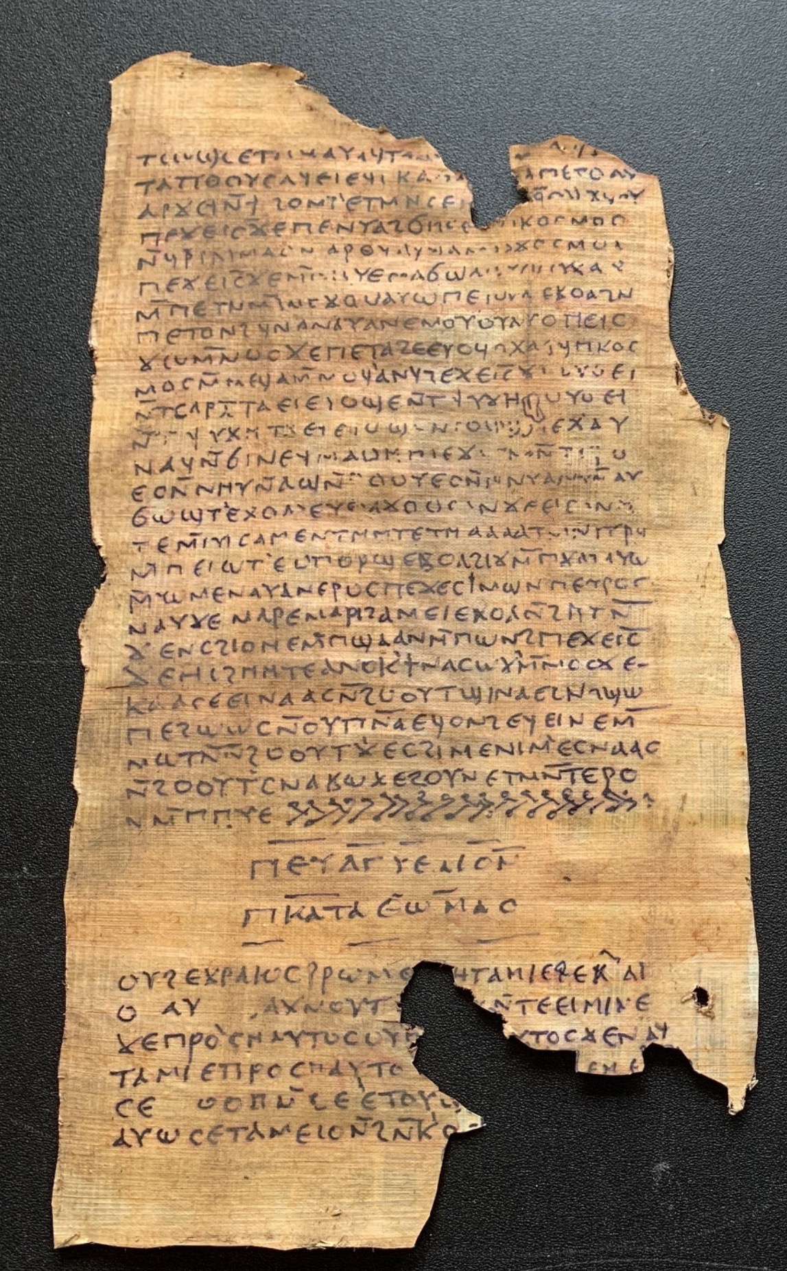 A framed display of two ancient-looking parchment scrolls filled with dense text.