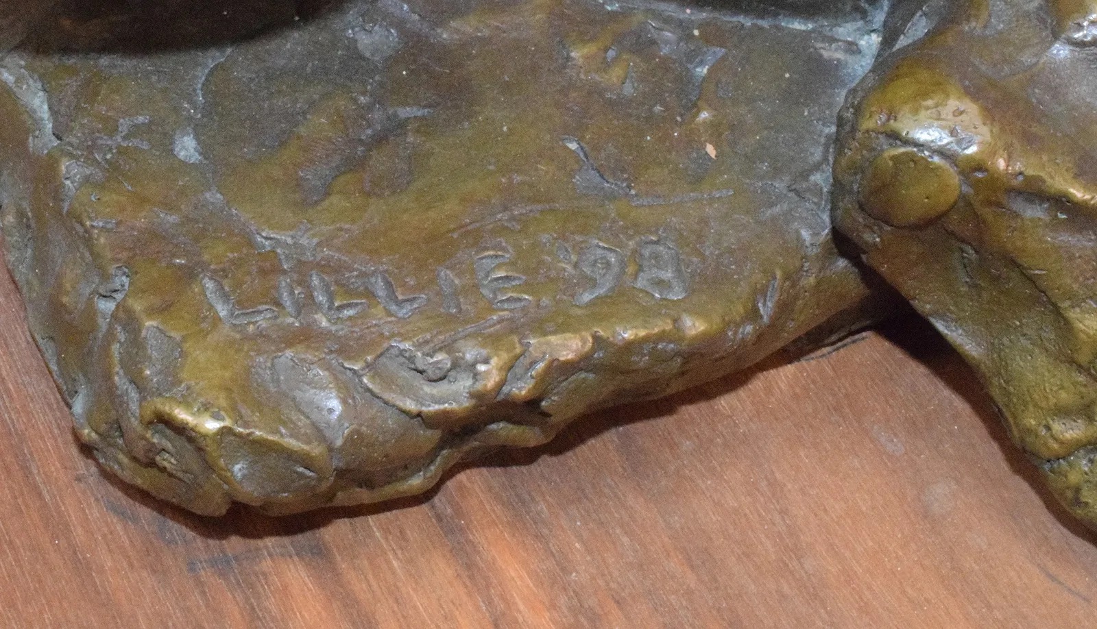 A bronze sculpture of a seated figure in deep contemplation.