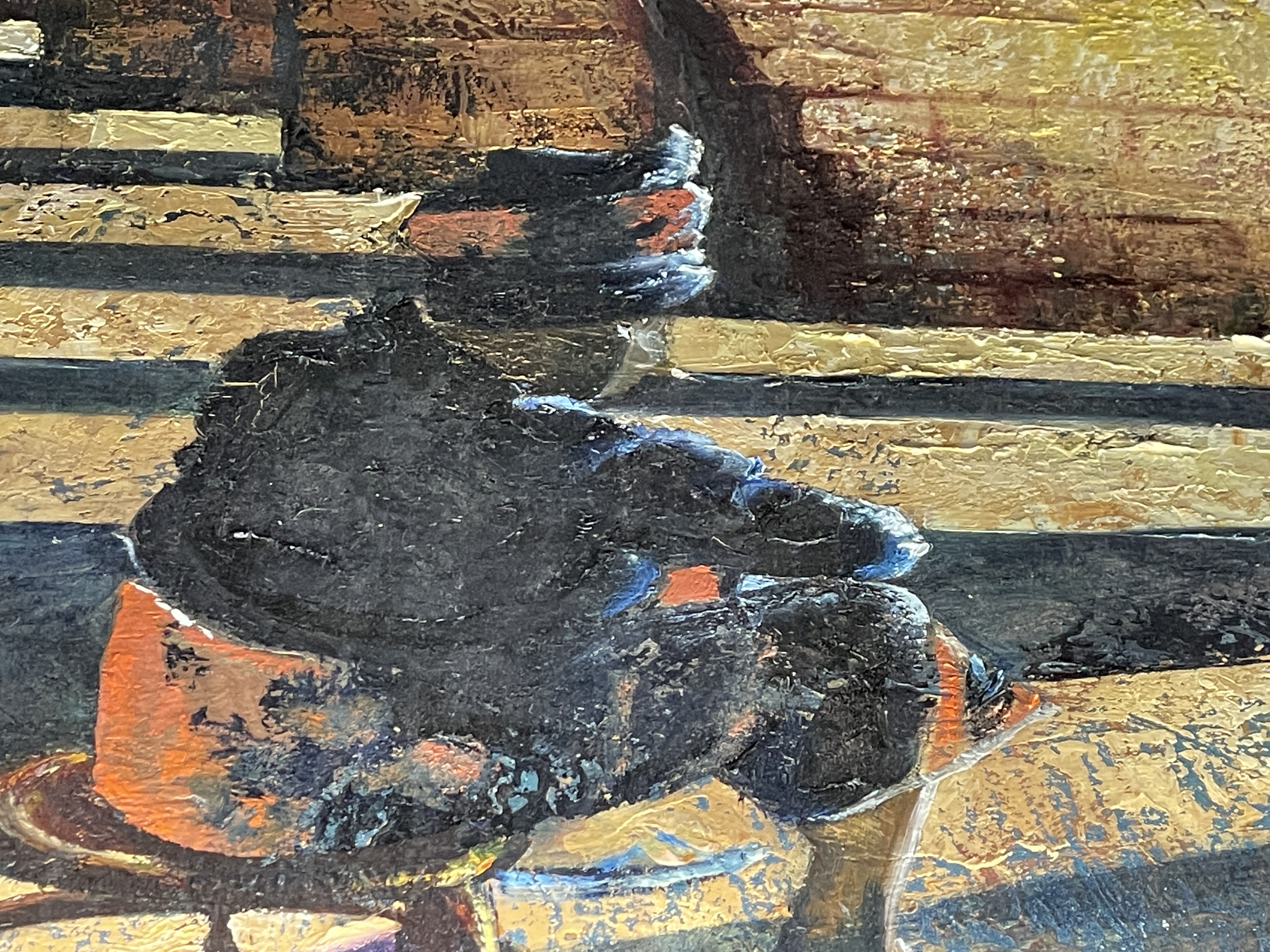 A gallery space features a large painting of an arched stone structure with a seated figure, displayed above a black bench.