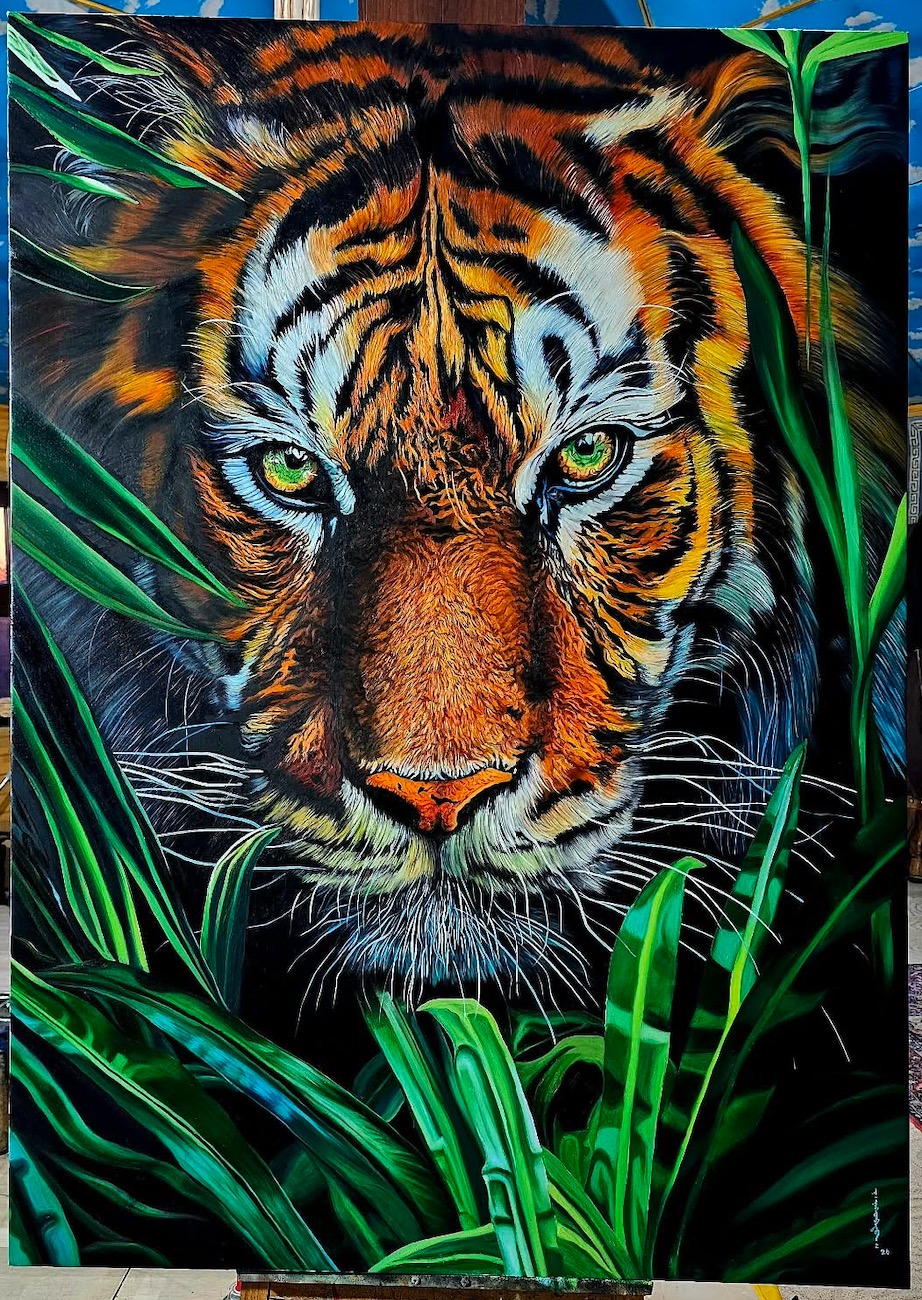 A person in a suit observes a large, hyper-realistic tiger painting amidst lush green foliage.