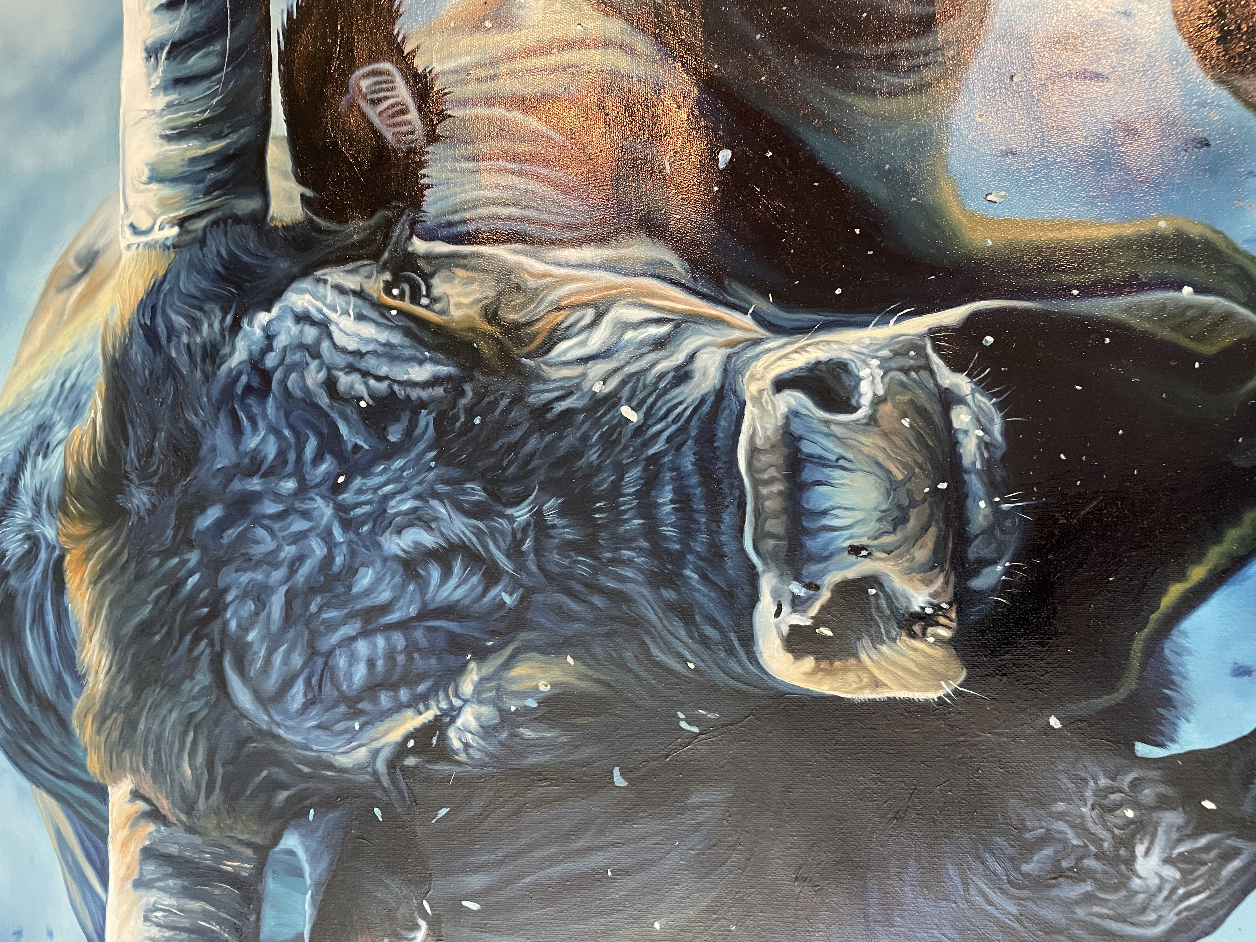 A woman in a black suit observes a large, dynamic painting of a bull against a deep blue background.