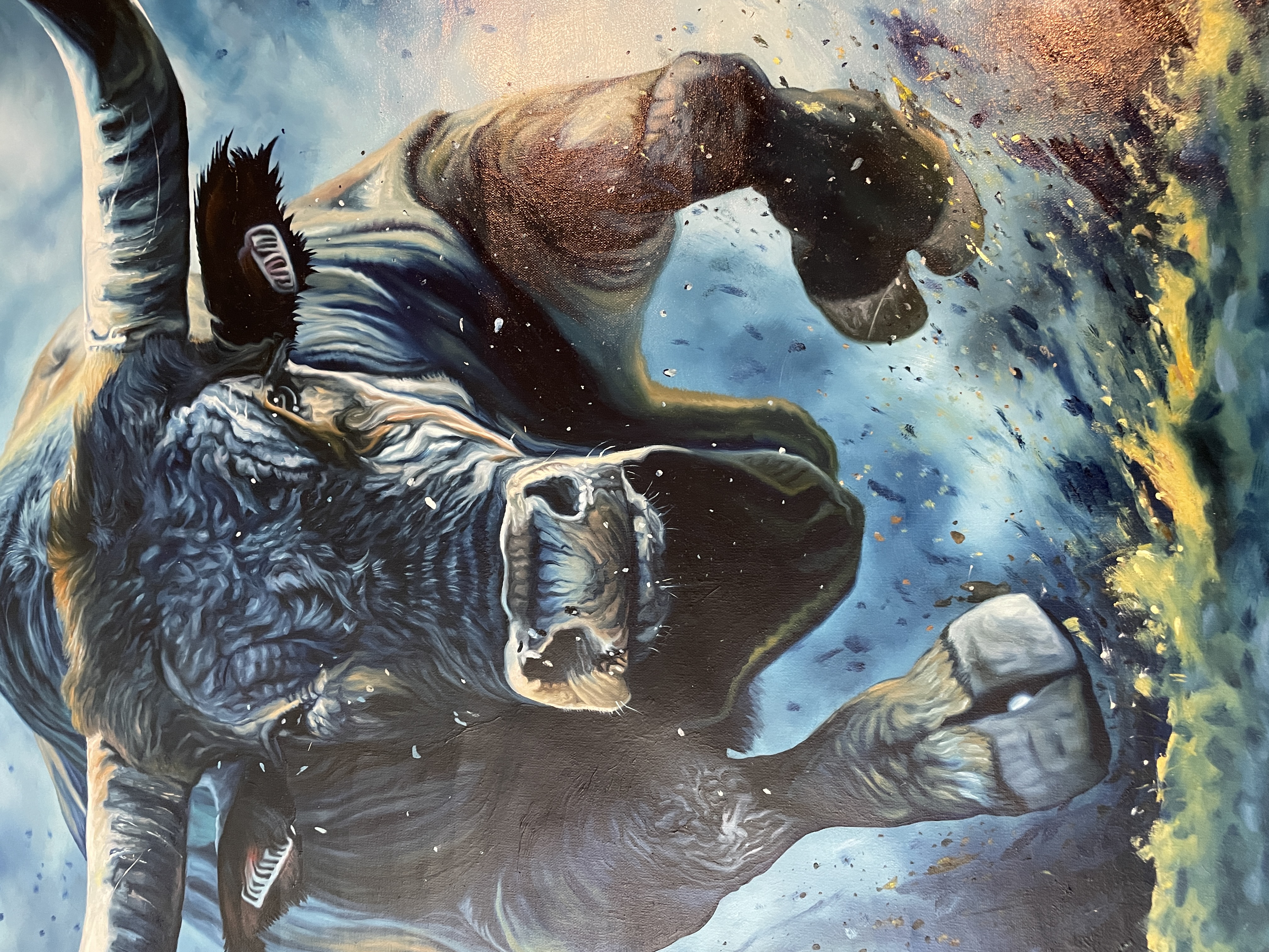 A woman in a black suit observes a large, dynamic painting of a bull against a deep blue background.
