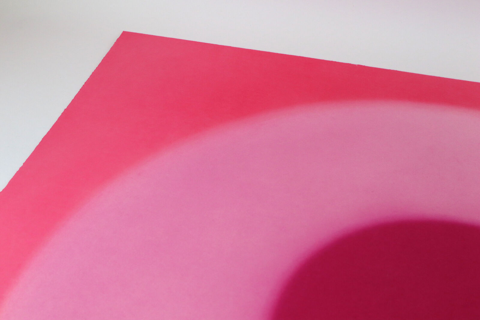 A minimalist abstract composition featuring concentric circles in shades of red and pink.