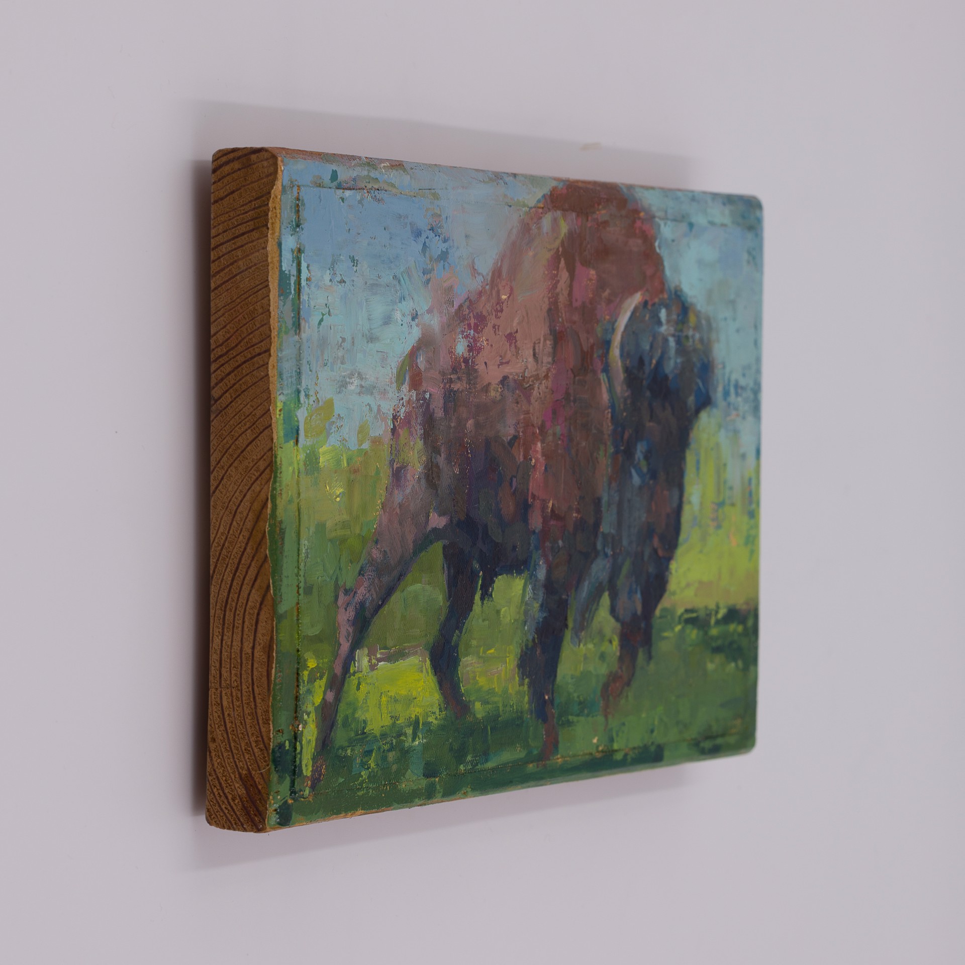 A bold, textured painting of a large bovine figure charging forward.
