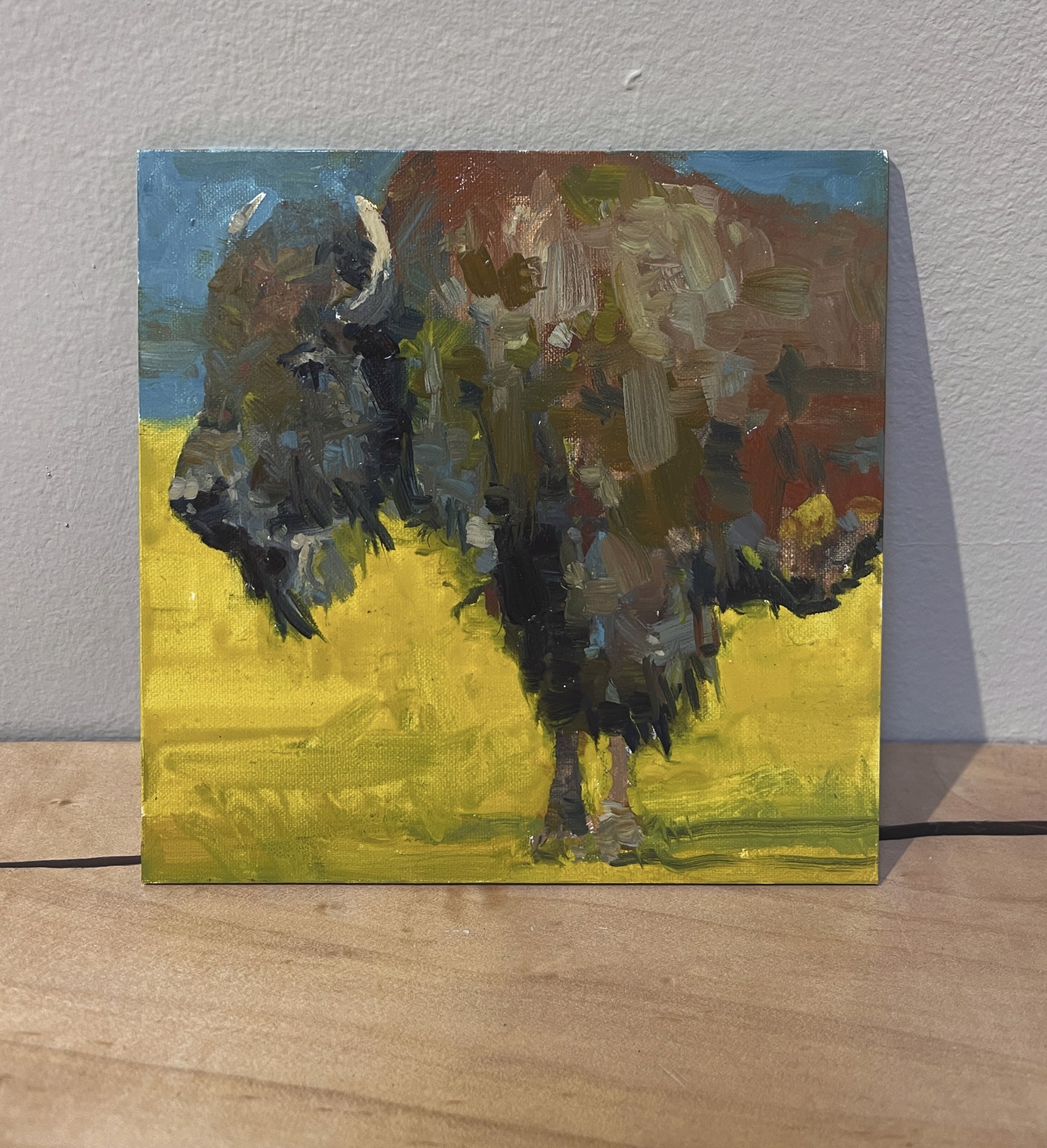 A painting of a bison standing in a field.