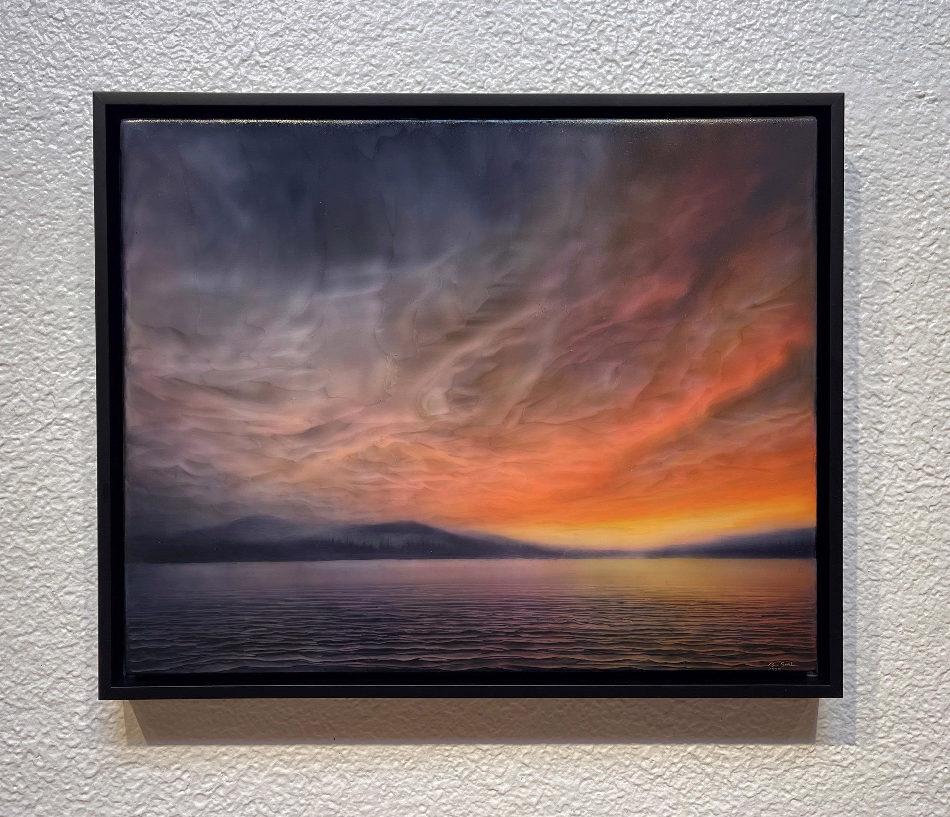 "A dramatic seascape at twilight featuring a textured sky and distant mountains."