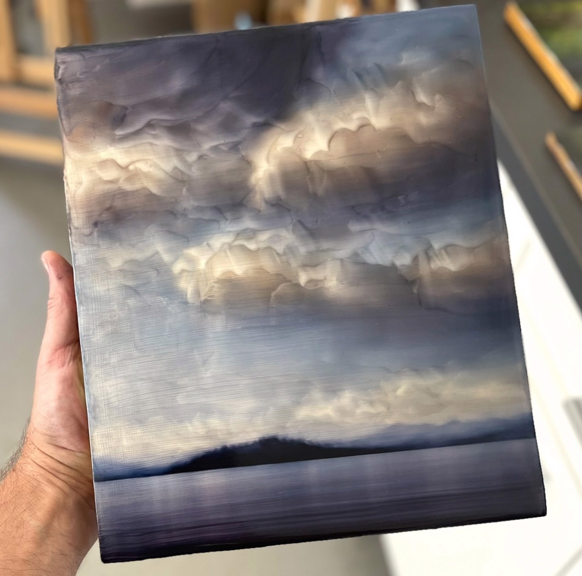 "A moody seascape painting featuring a dark silhouette of land against a dramatic, textured sky."