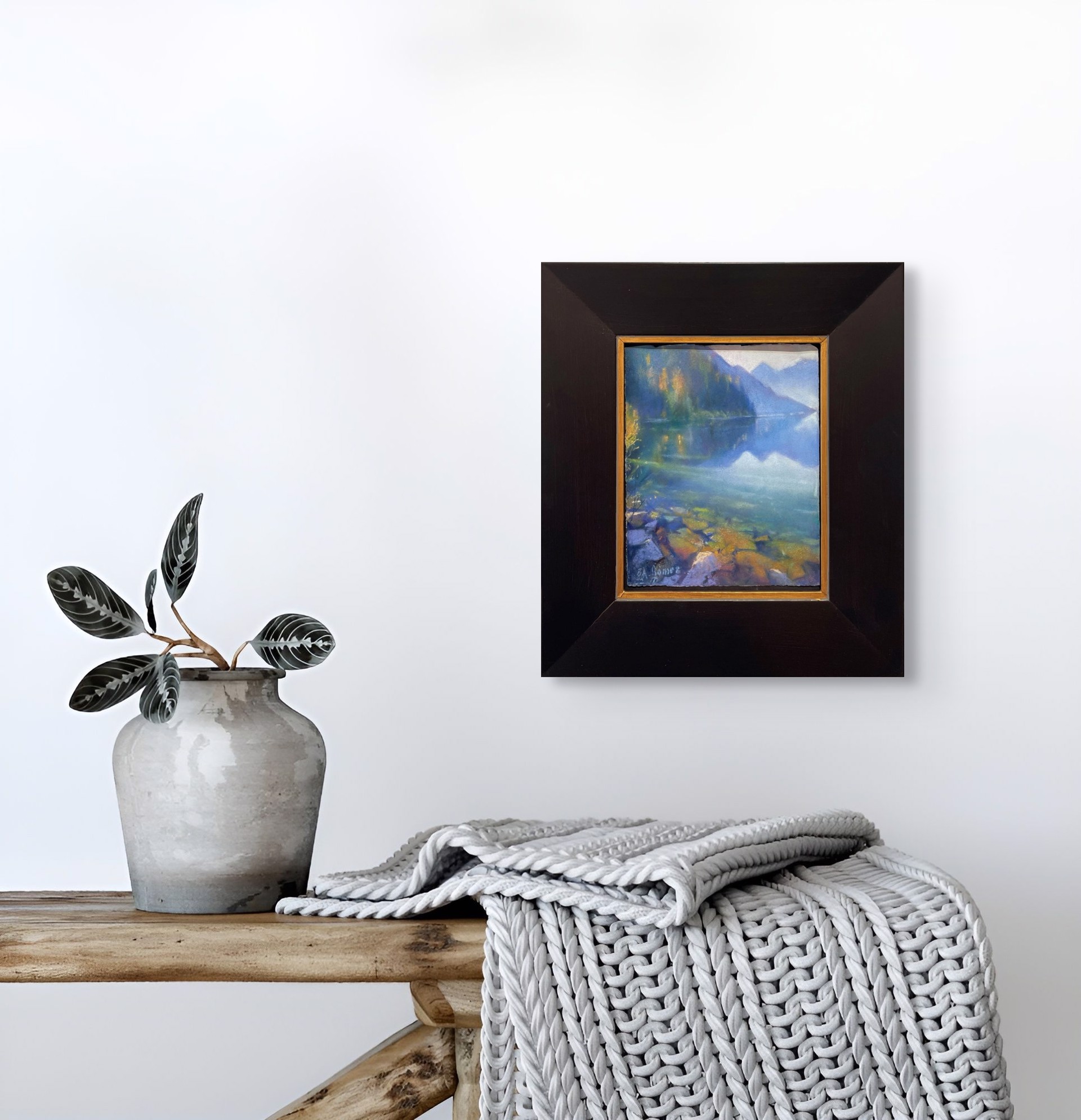 A painting of a lake with mountains in the background.