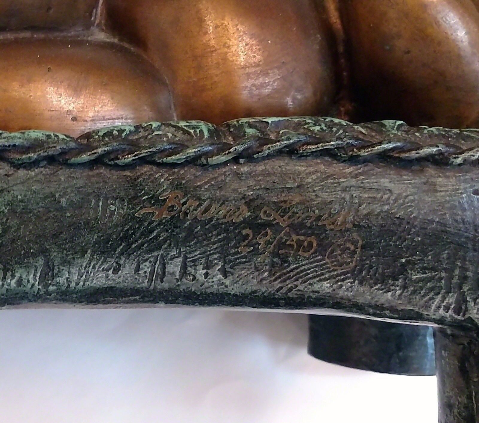 A bronze statue of a woman laying on a couch.