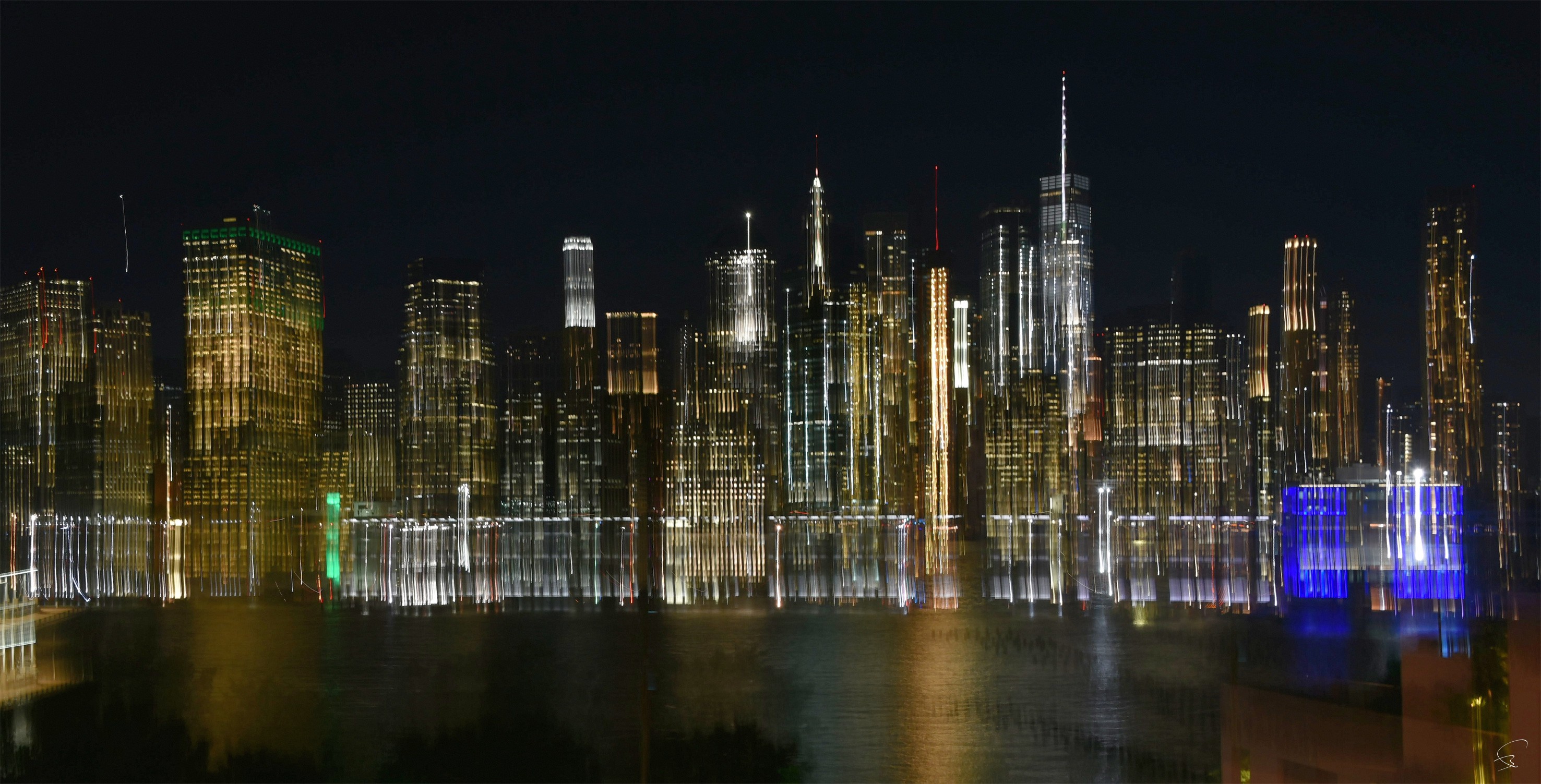A view of a city skyline at night from across the water.