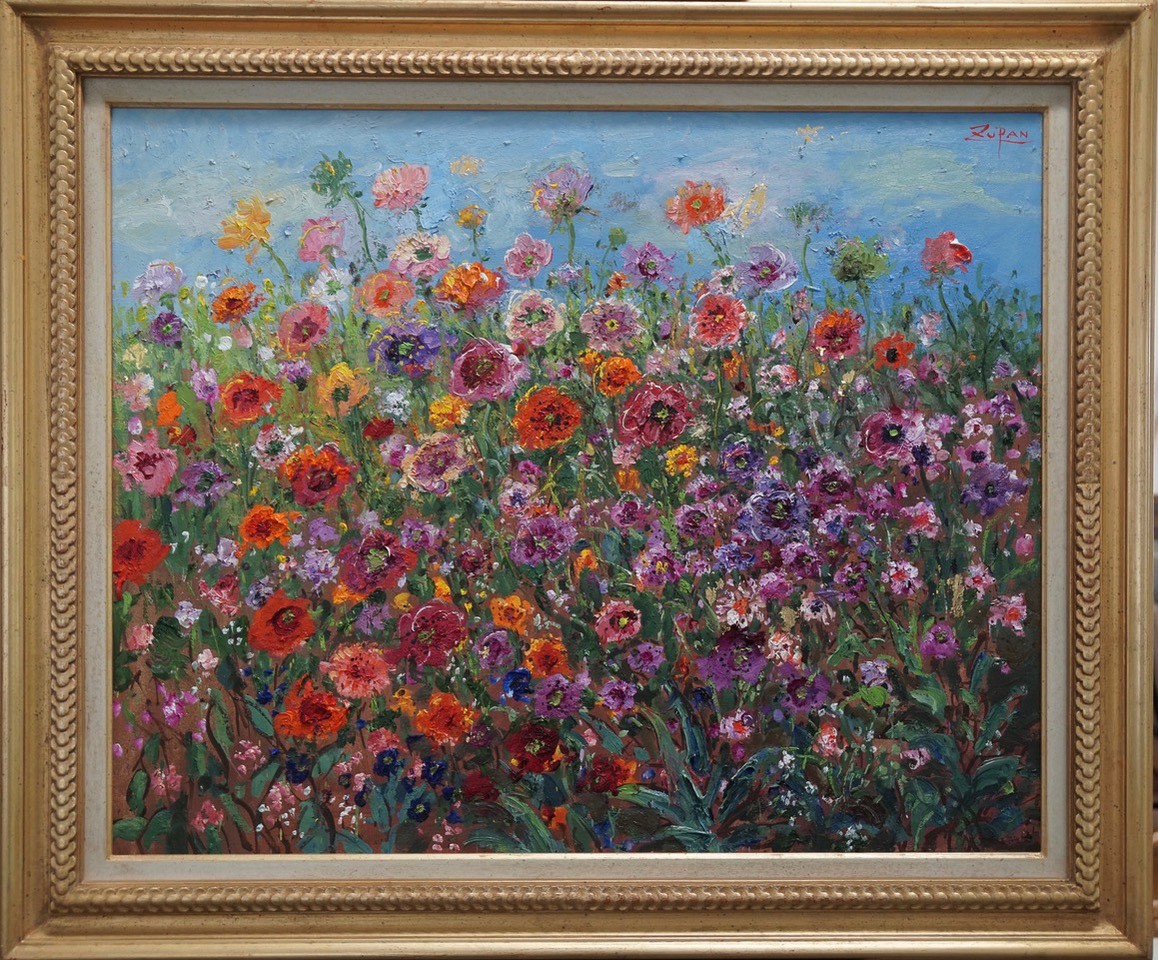 A painting of a field of flowers in a gold frame.