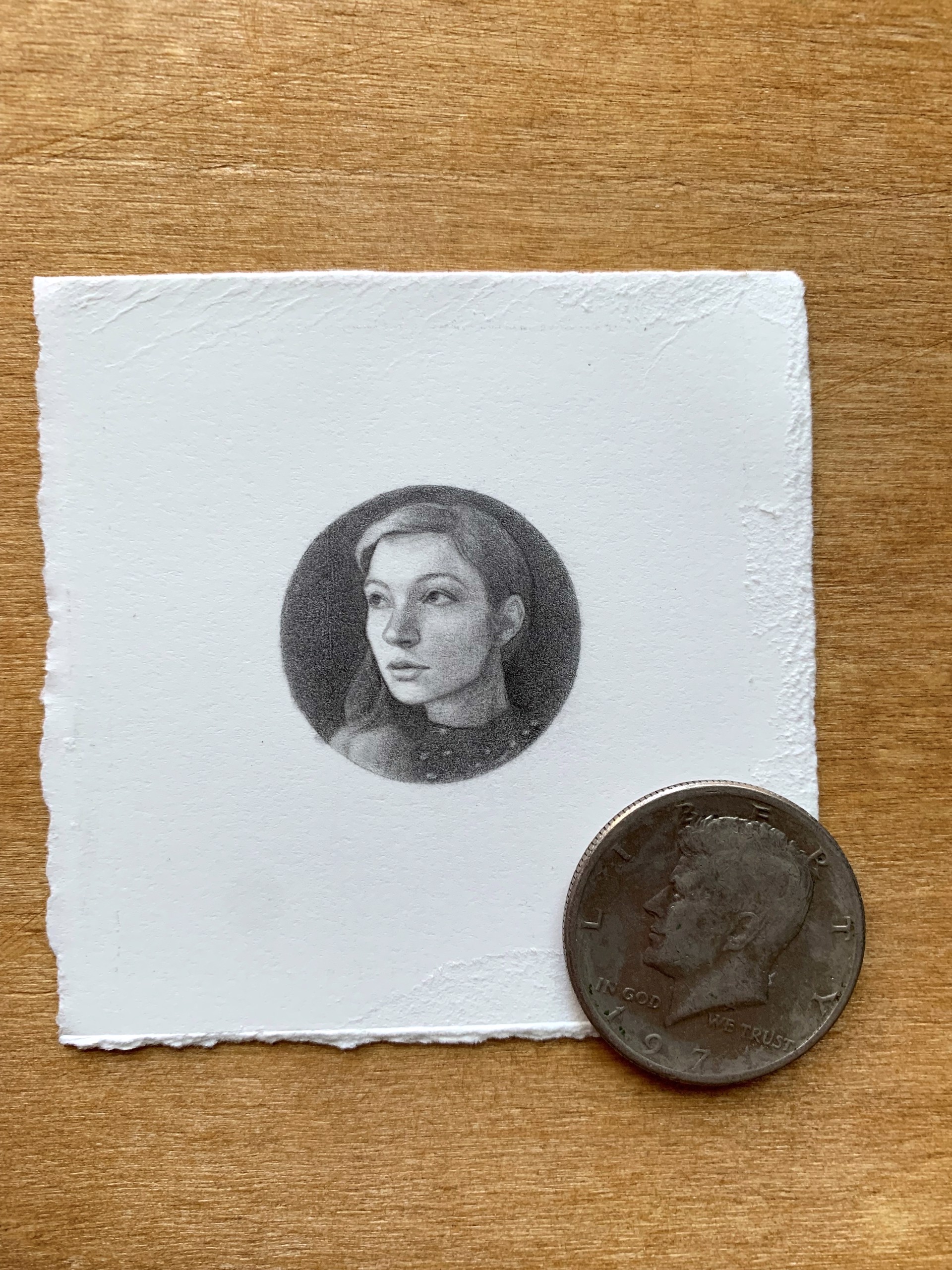 A black and white drawing of a woman's face in a circle.