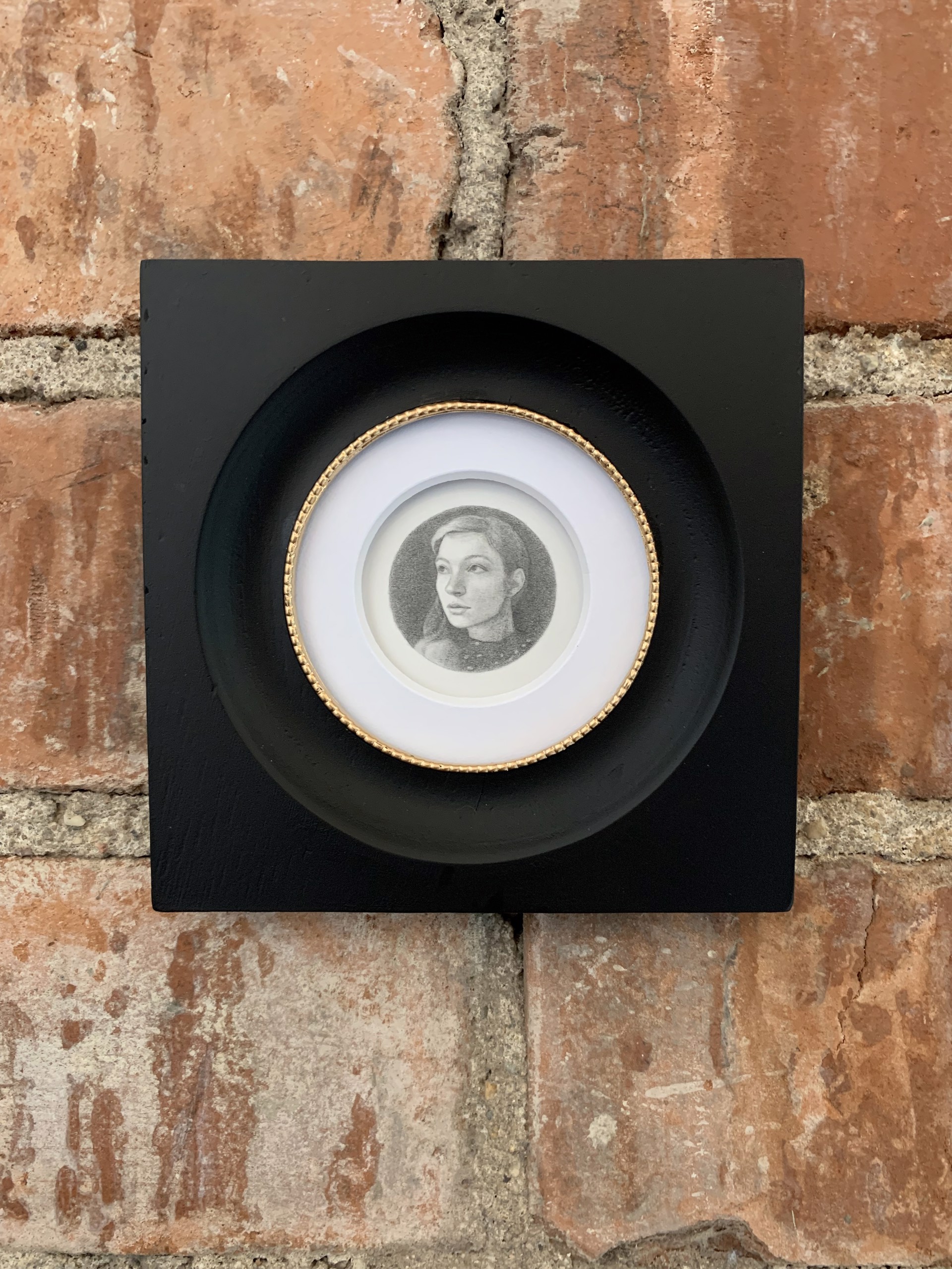 A black and white drawing of a woman's face in a circle.