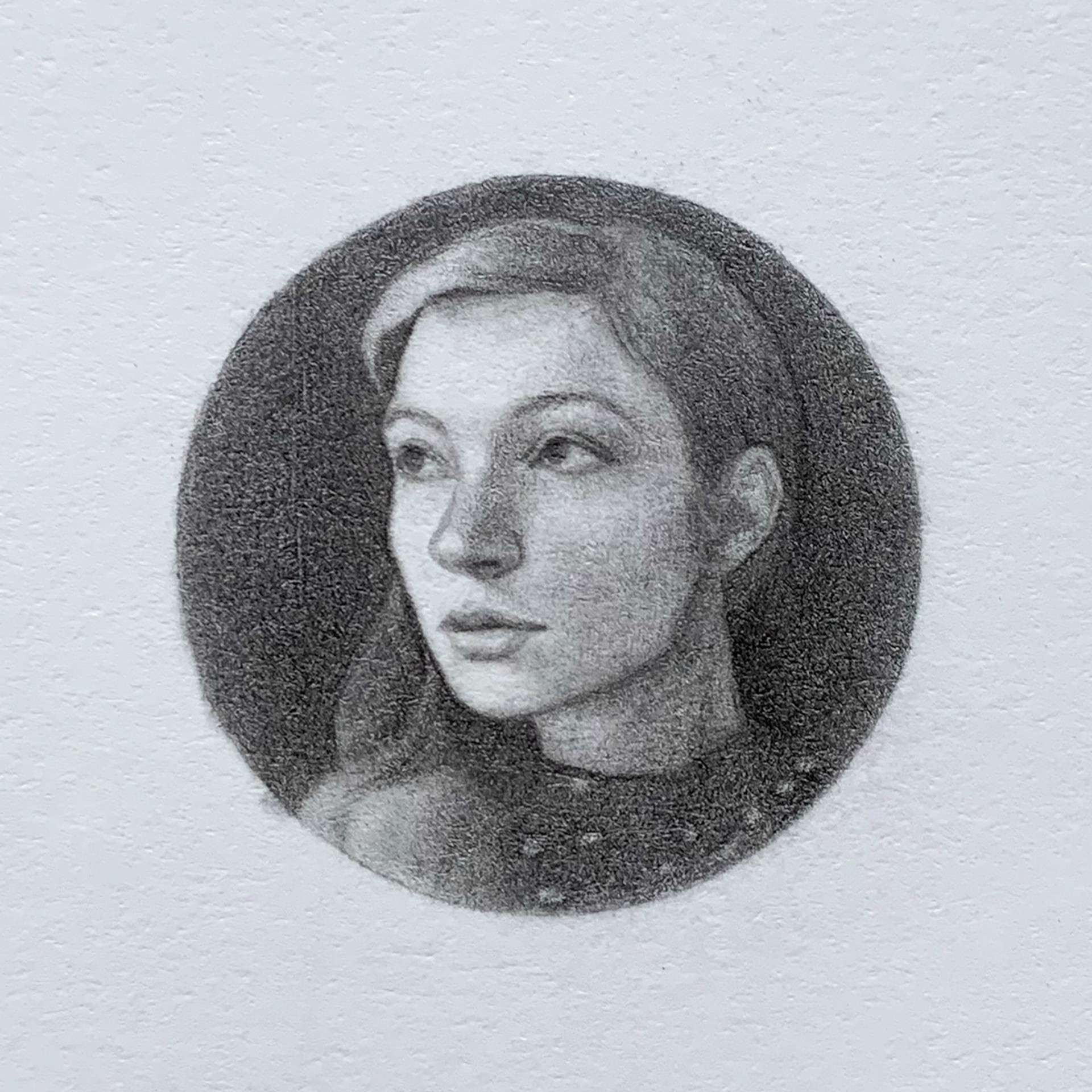 A black and white drawing of a woman's face in a circle.