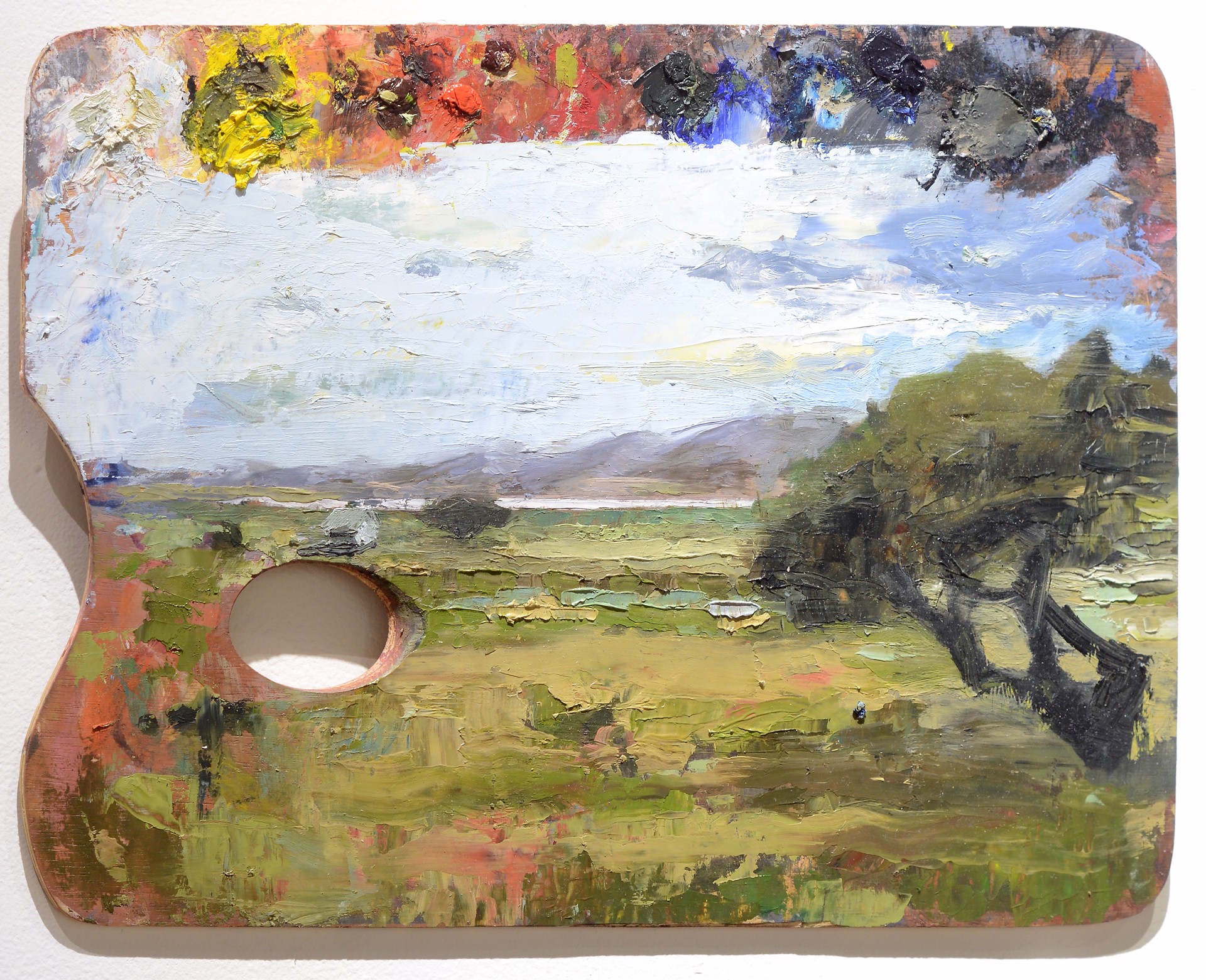 A painting on a wooden palette with a hole in it.