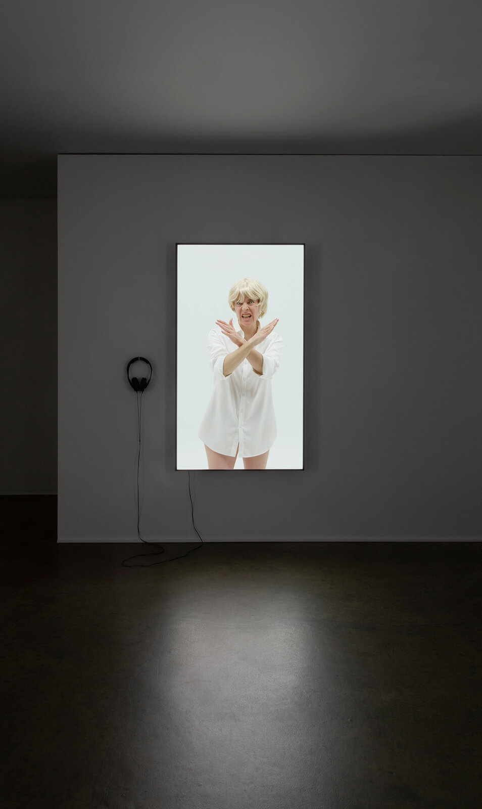 A picture of a woman in a white shirt on a wall.
