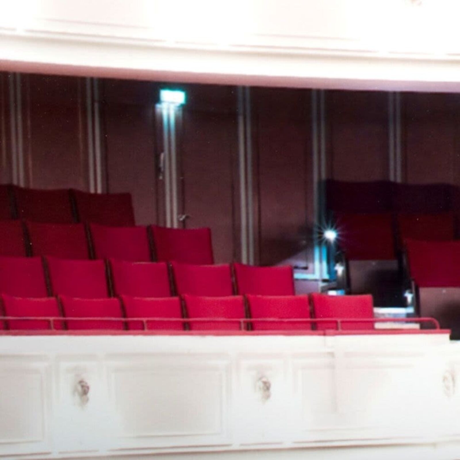 A picture of a large auditorium with red seats.