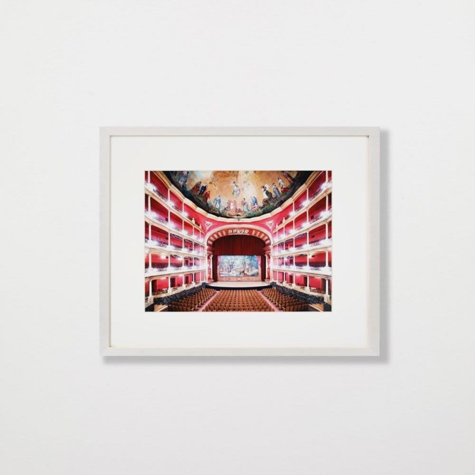 A picture of an empty theater with a painting on the ceiling.