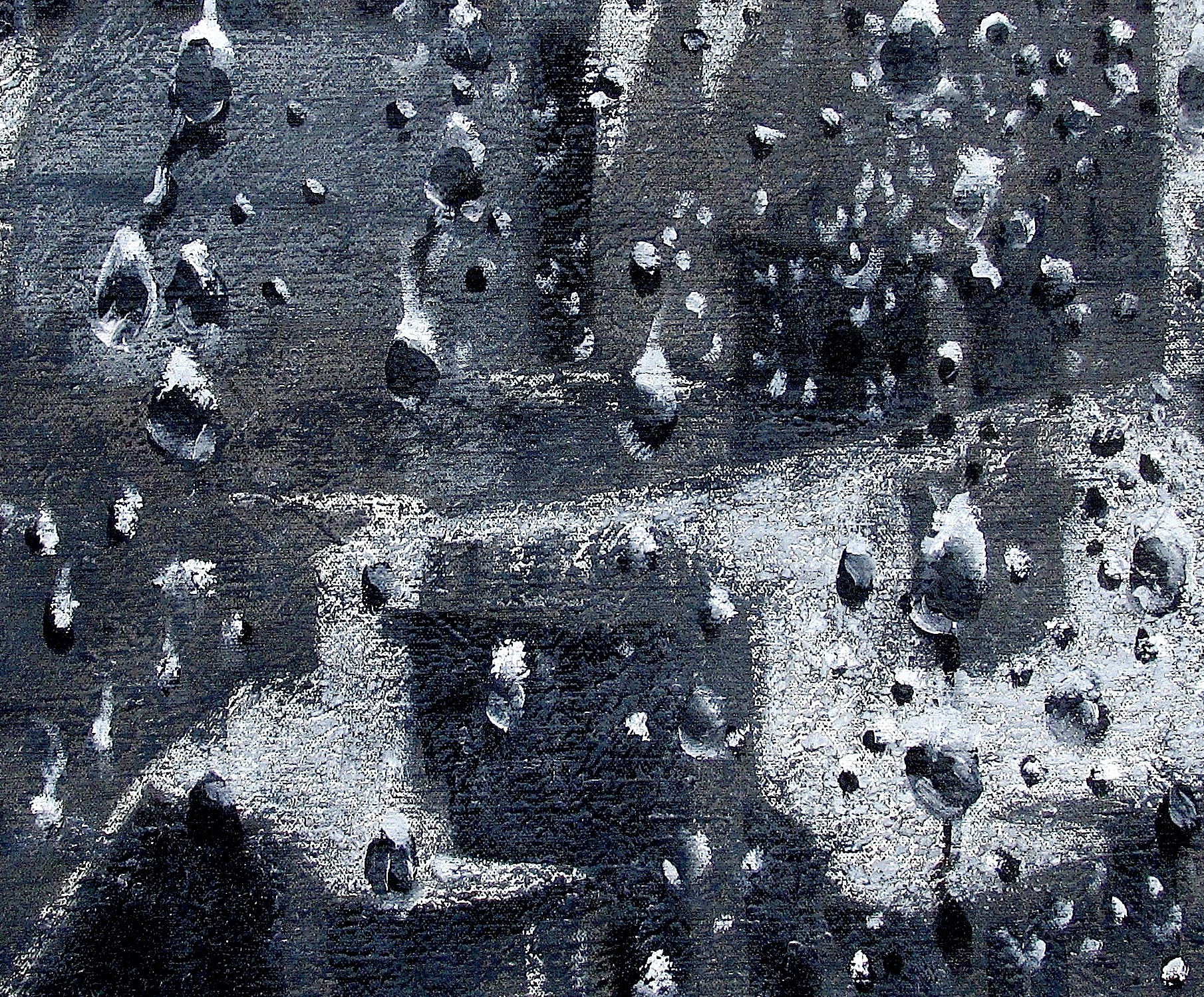 A black and white photo of water droplets on a metal surface.