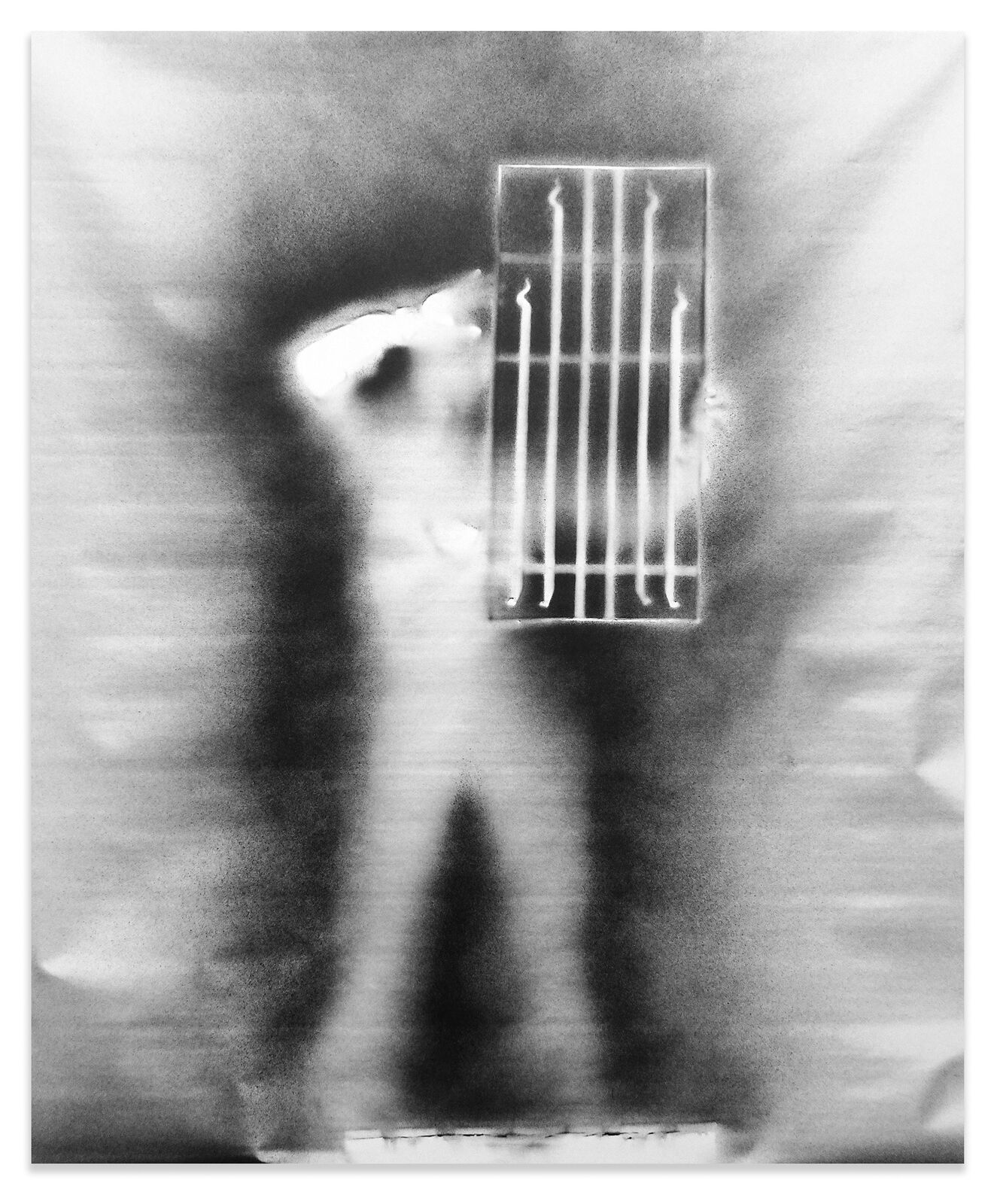 A black and white photo of a person standing in front of a jail cell.