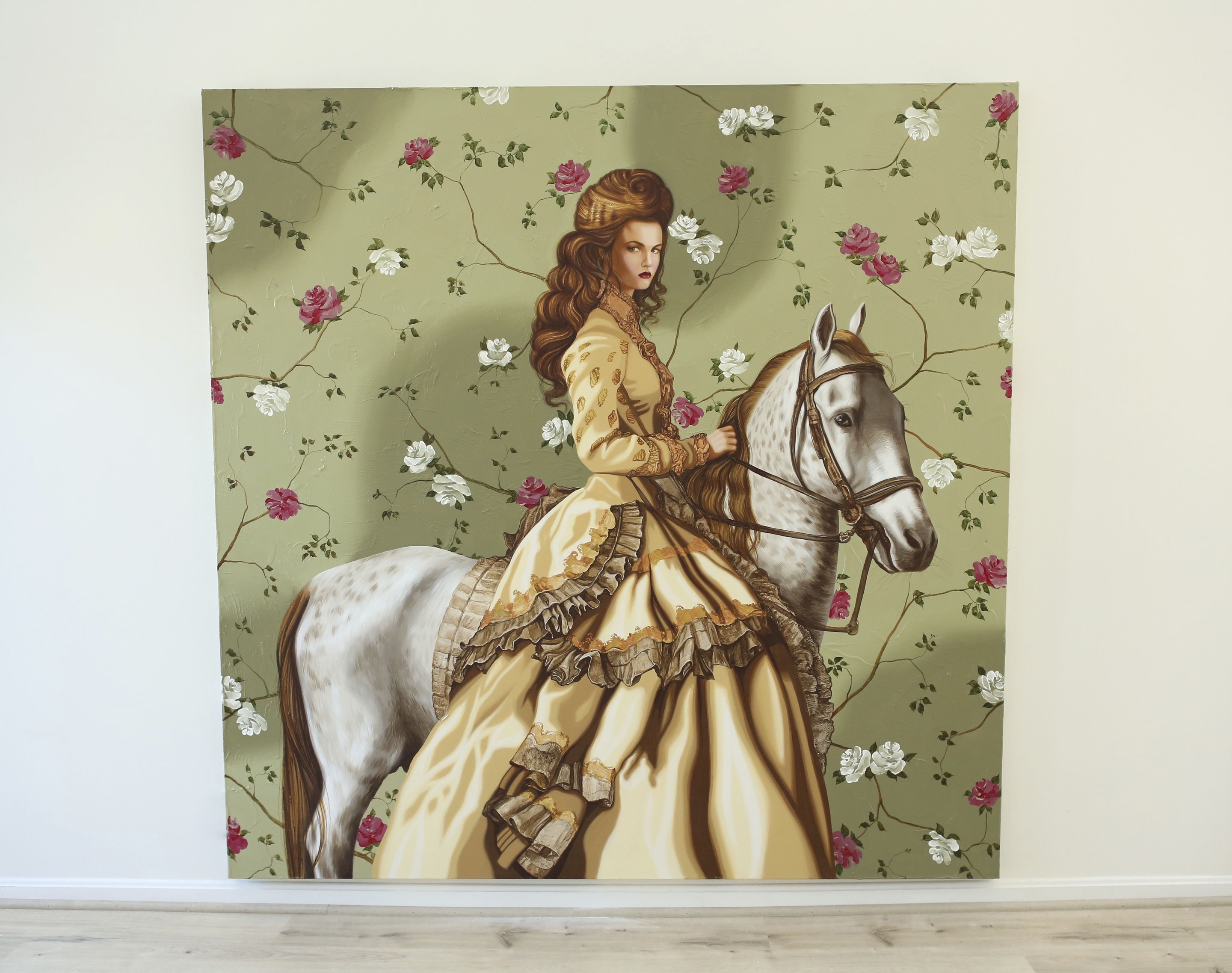 A woman riding a white horse in front of a floral wallpaper.