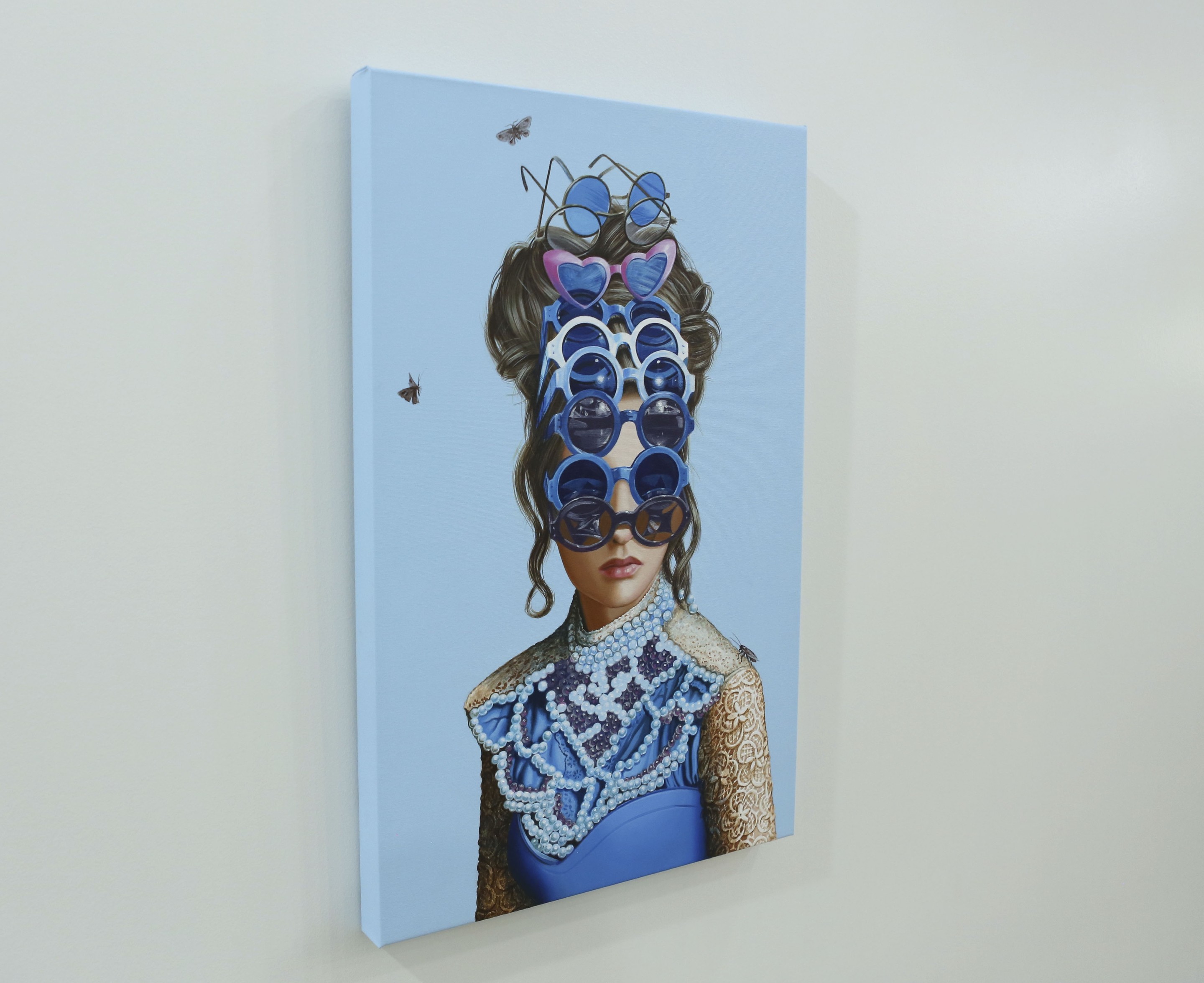 A painting of a woman wearing sunglasses on a wall.