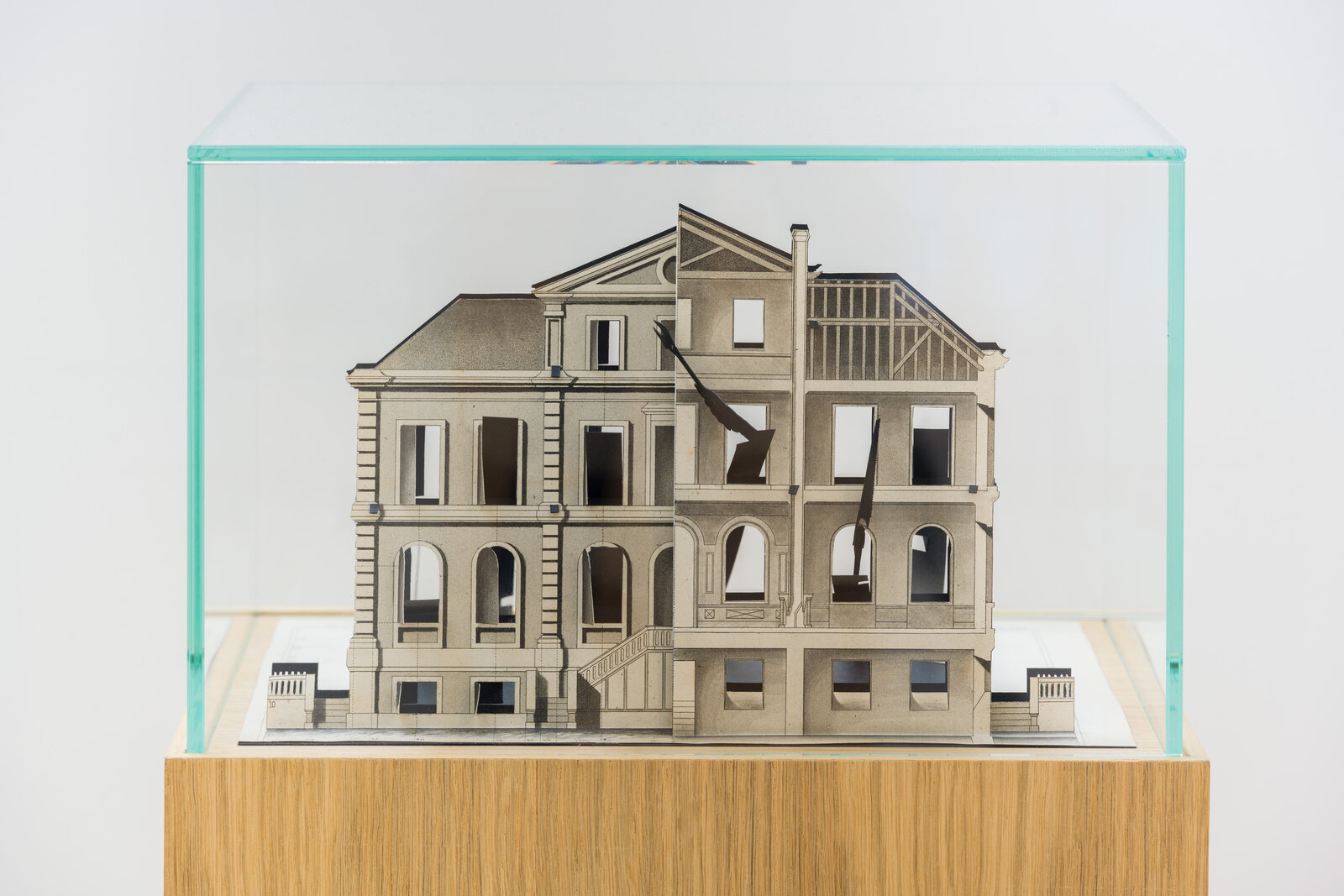 A diorama of a split building model inside a glass case.