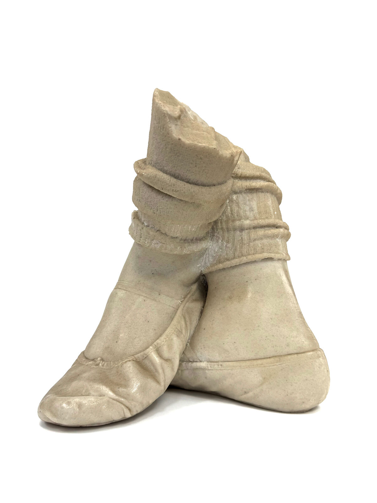 A pair of beige shoes with a hat on top of them.