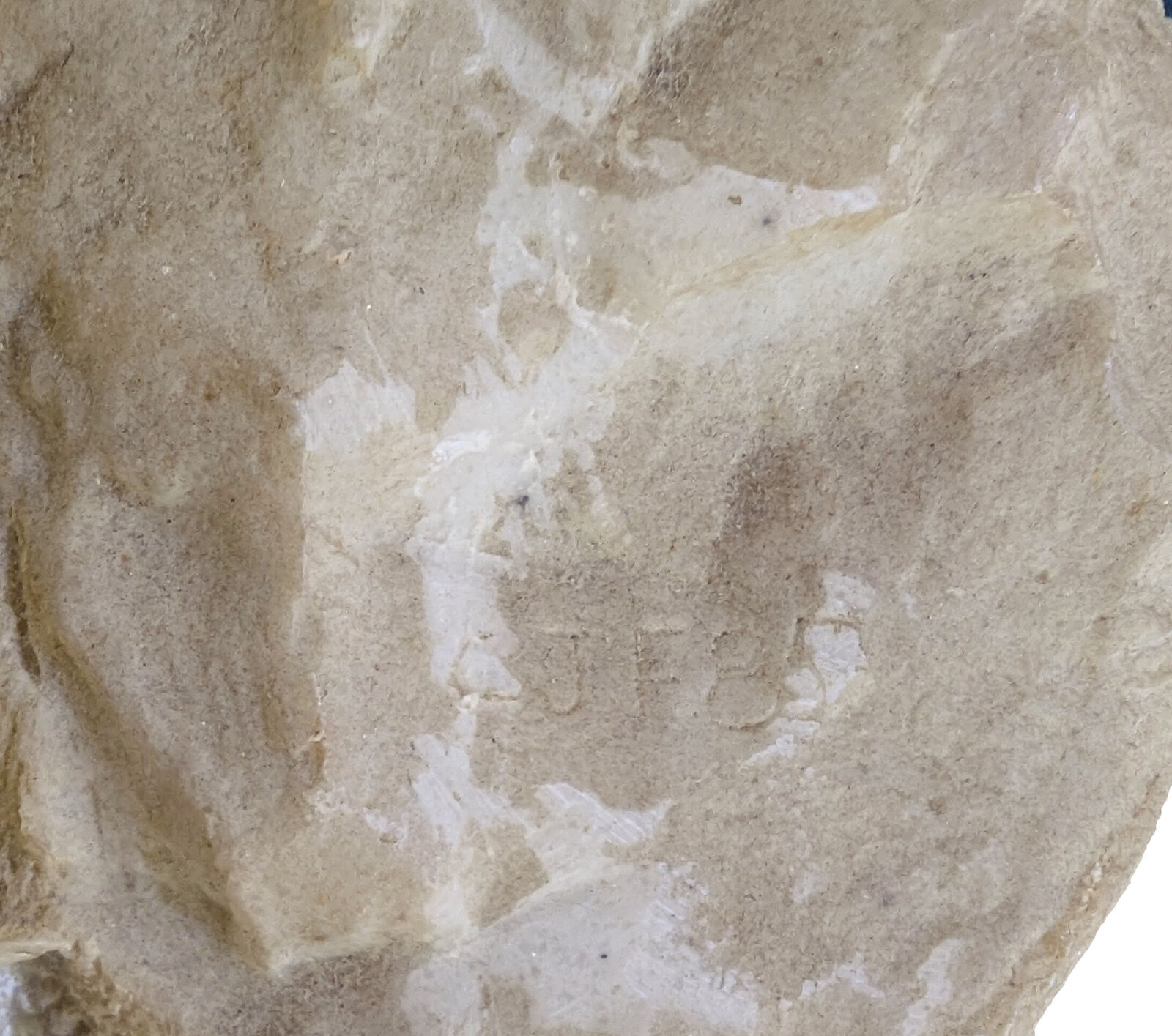 A pair of beige shoes with a hat on top of them.