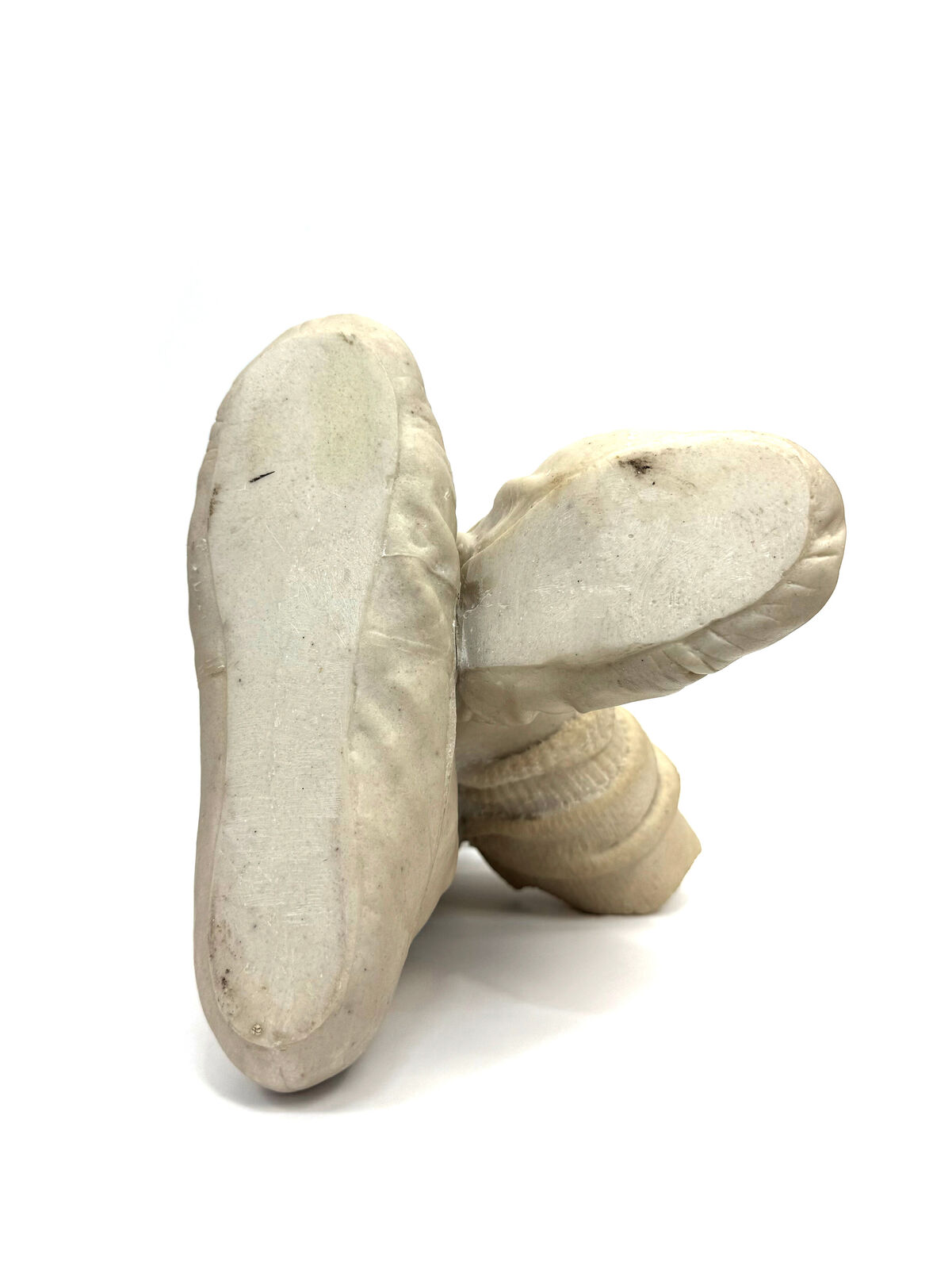 A pair of beige shoes with a hat on top of them.