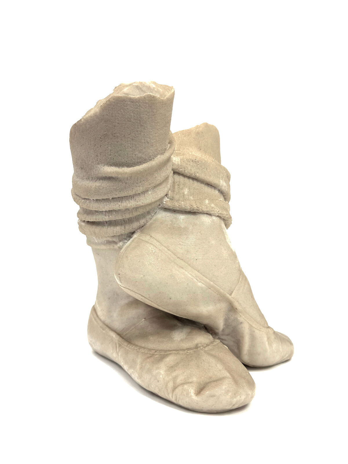 A pair of beige shoes with a hat on top of them.