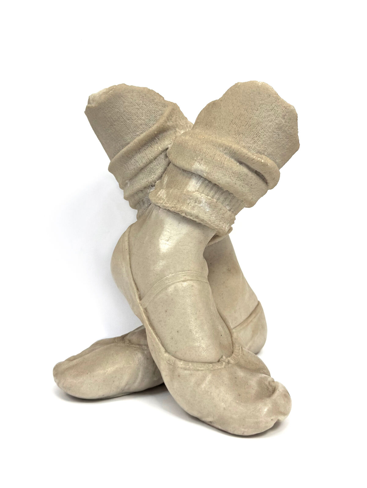 A pair of beige shoes with a hat on top of them.