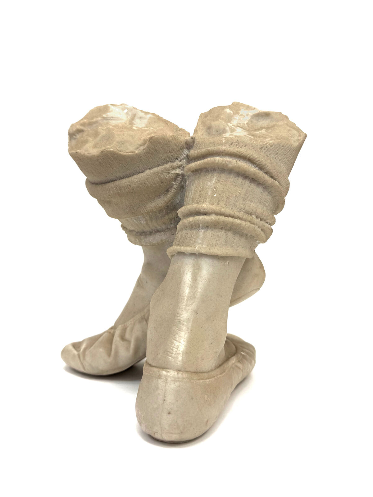 A pair of beige shoes with a hat on top of them.