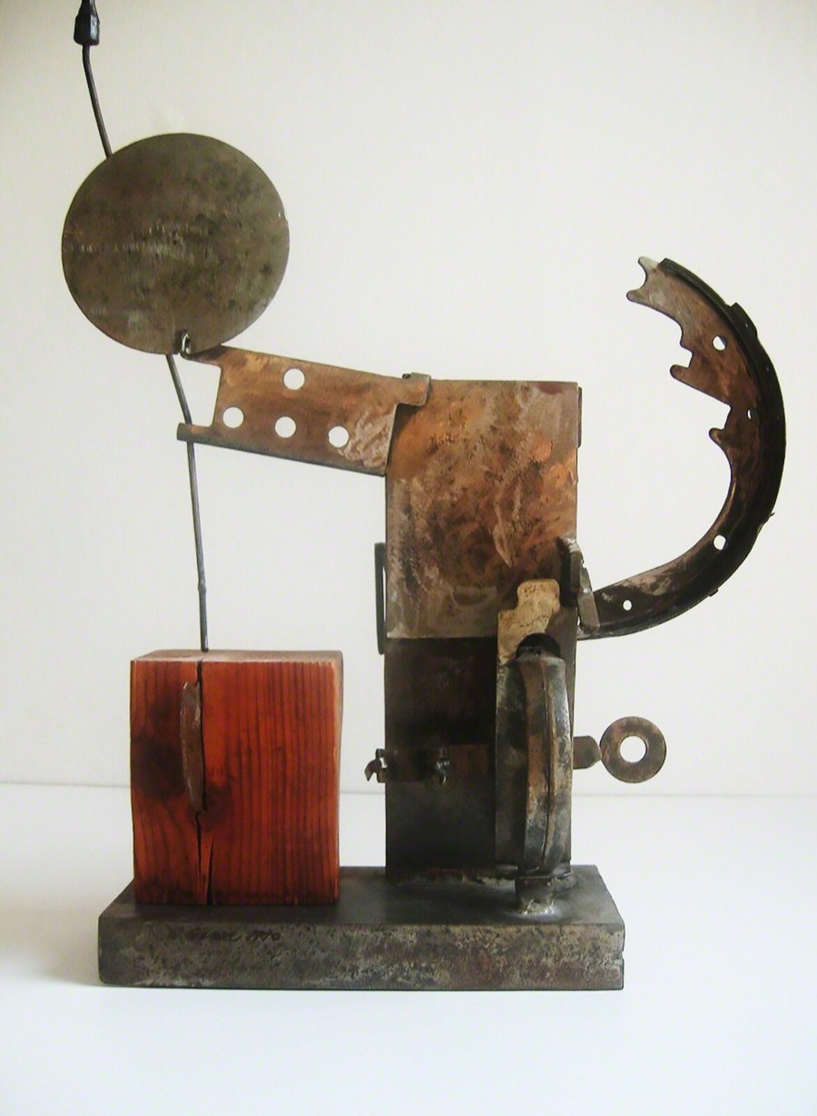 A metal sculpture of a man holding a piece of wood.