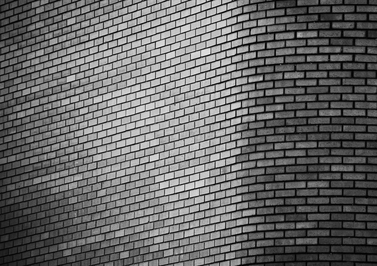 A black and white photo of a brick wall.