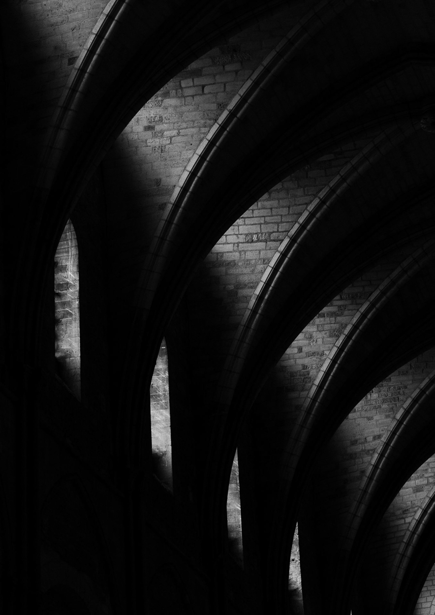 A black and white photo of arches in a building.