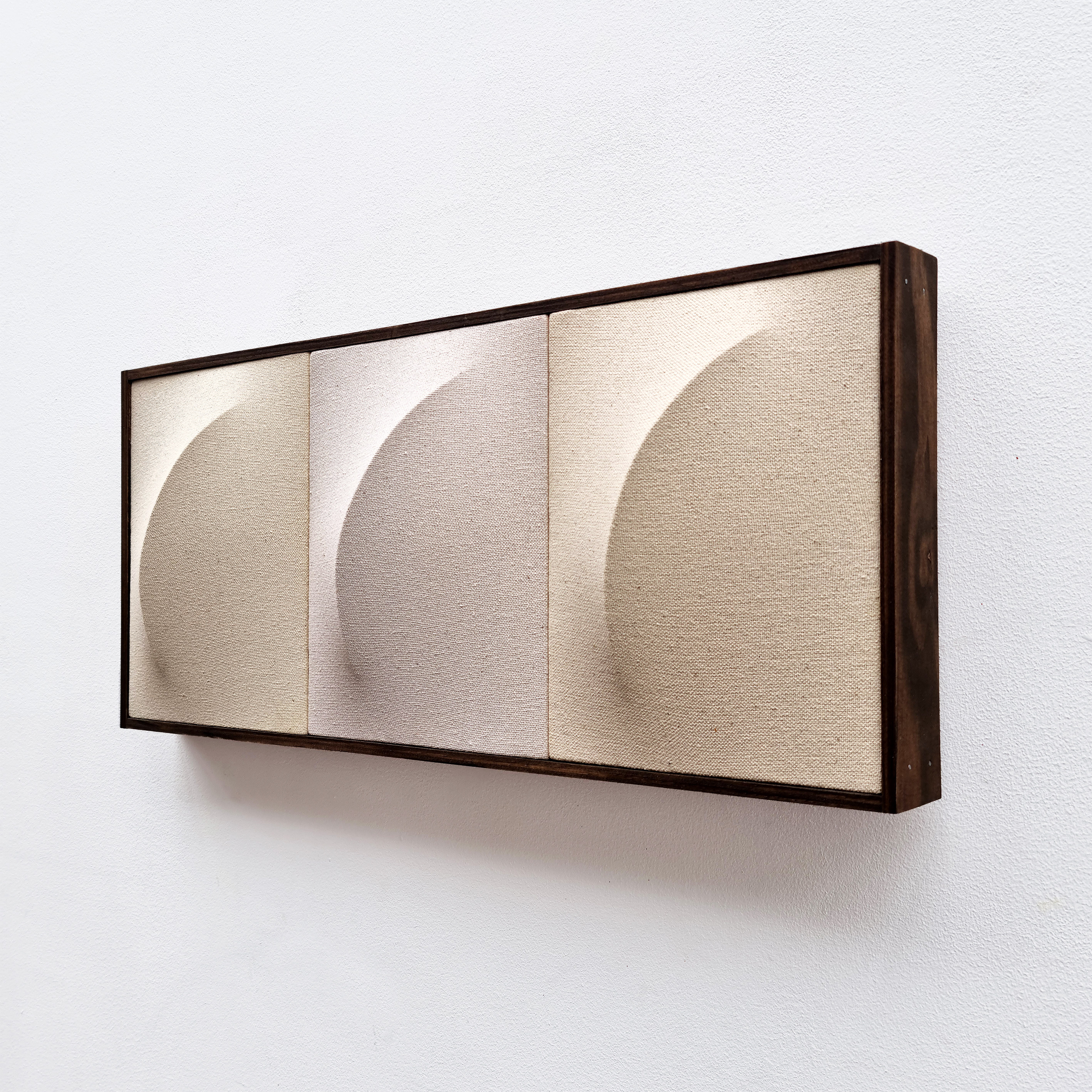 A picture of three different shapes in a wooden frame.
