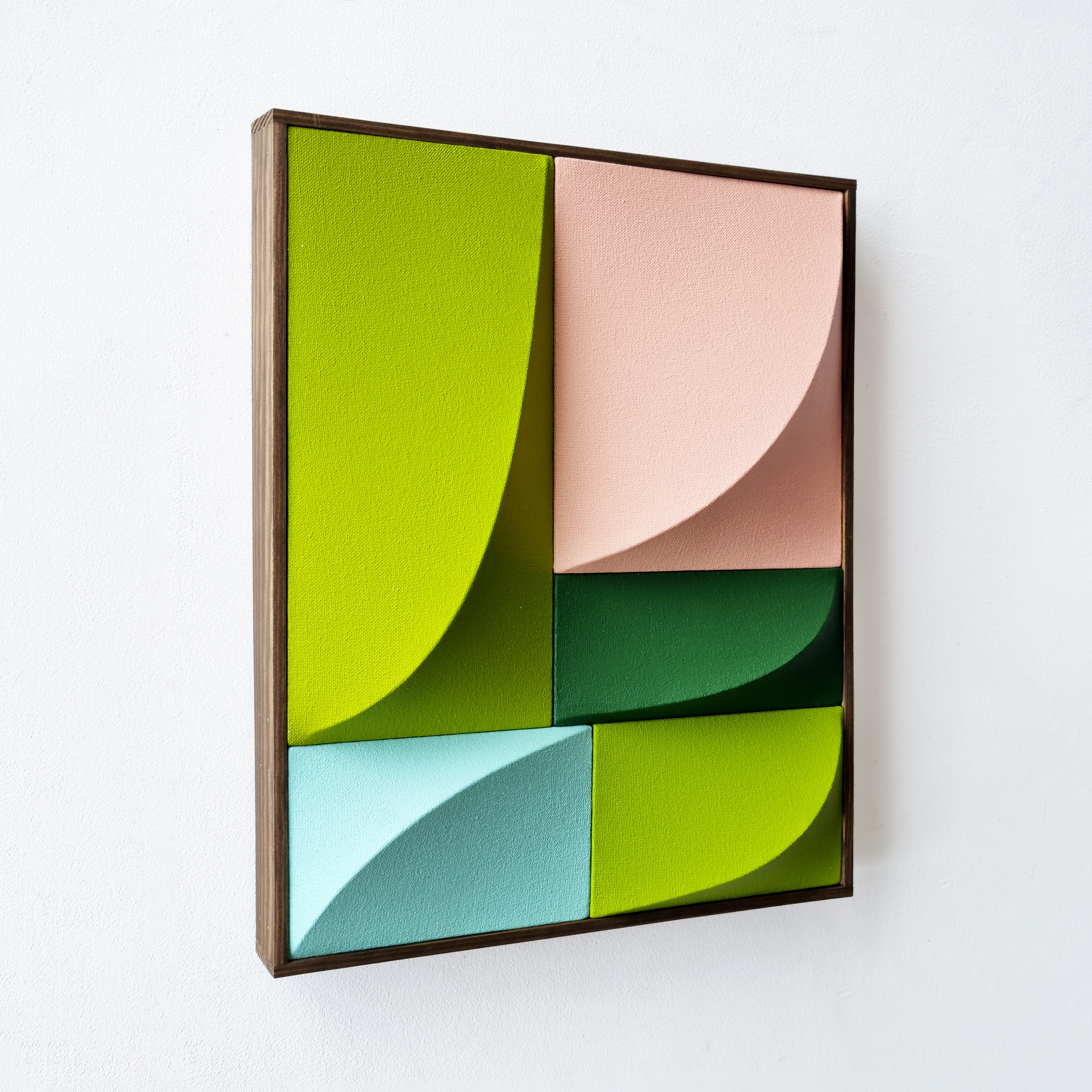 A picture of a green, pink, and blue abstract painting on a wall.