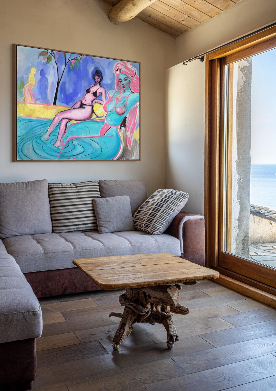 A painting of two women sitting on a beach chair.