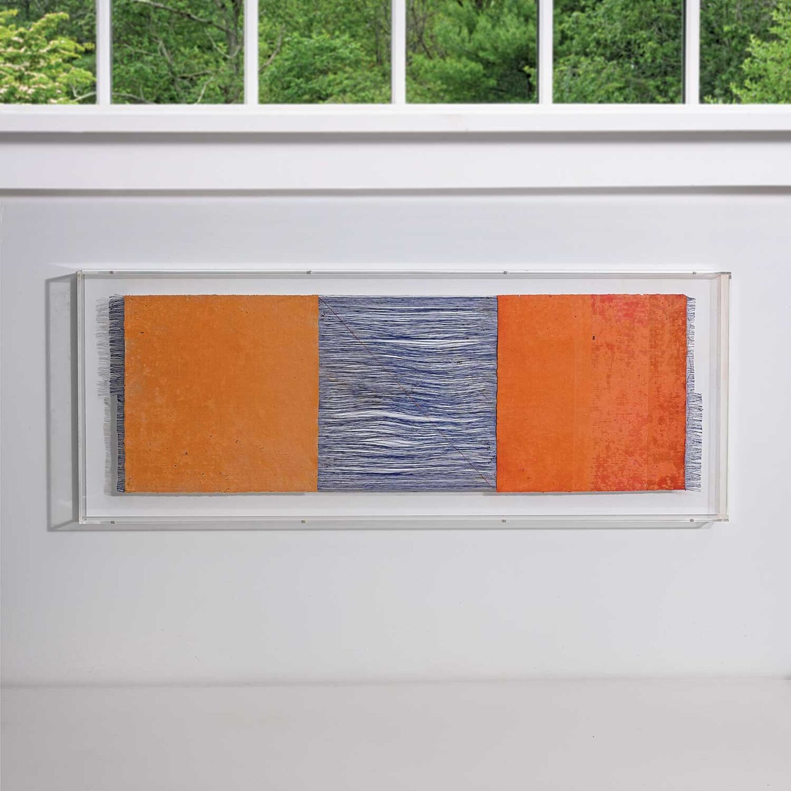 A painting hanging on a wall in front of a window.