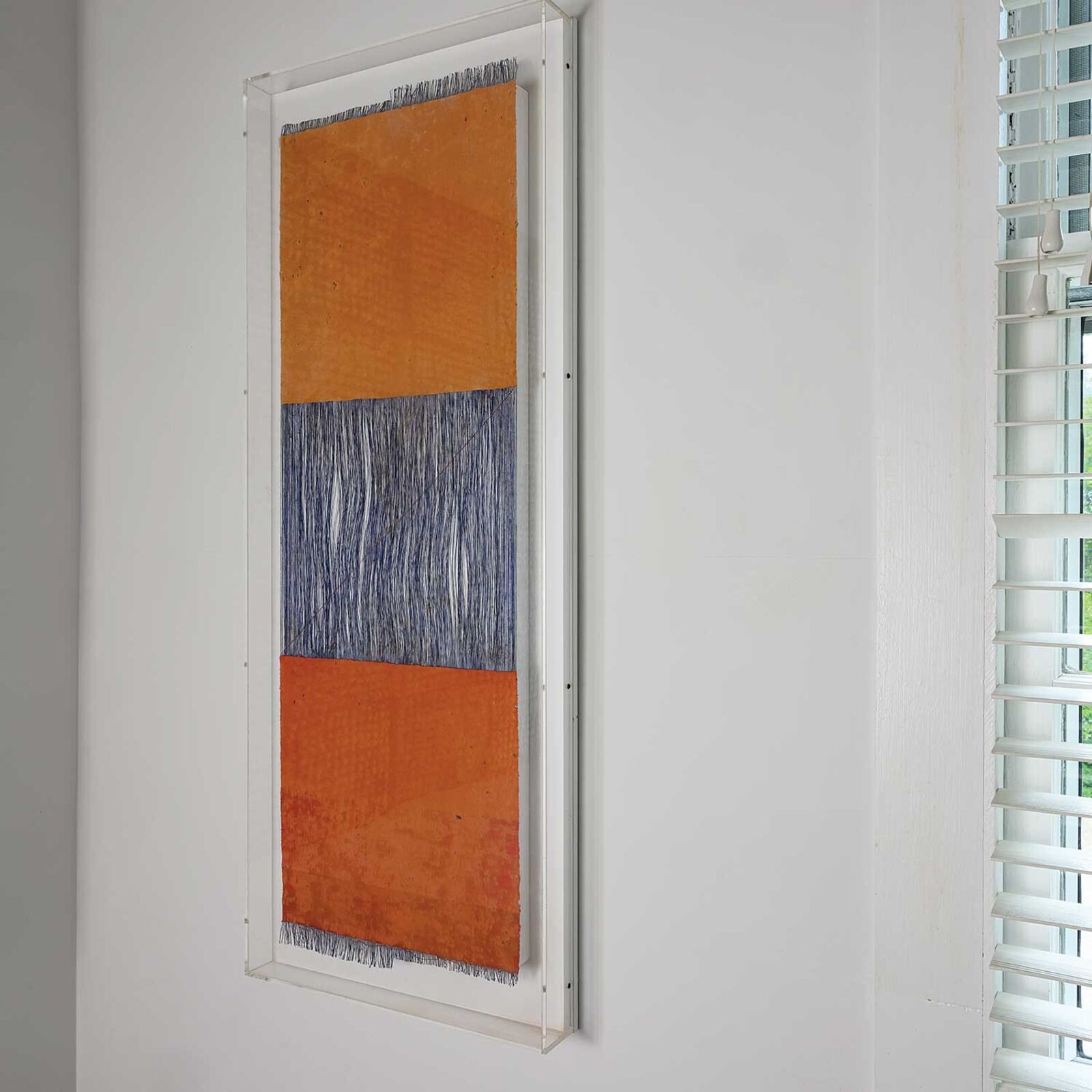 A painting hanging on a wall in front of a window.