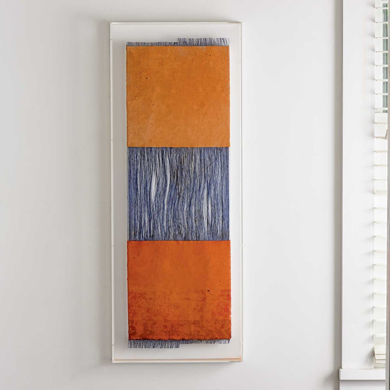 A painting hanging on a wall in front of a window.