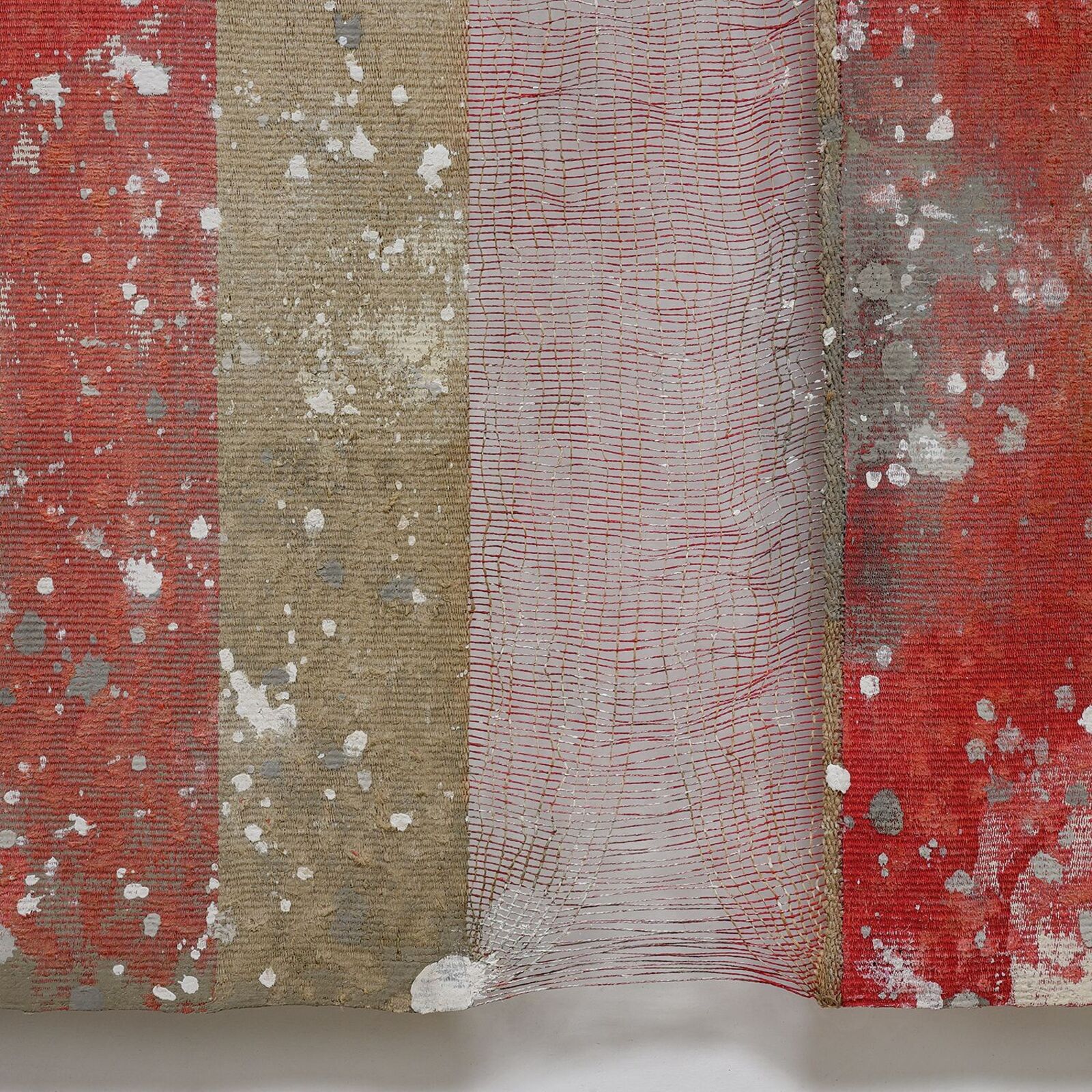 A framed textile artwork featuring vertical red and beige stripes with a weathered, speckled texture.