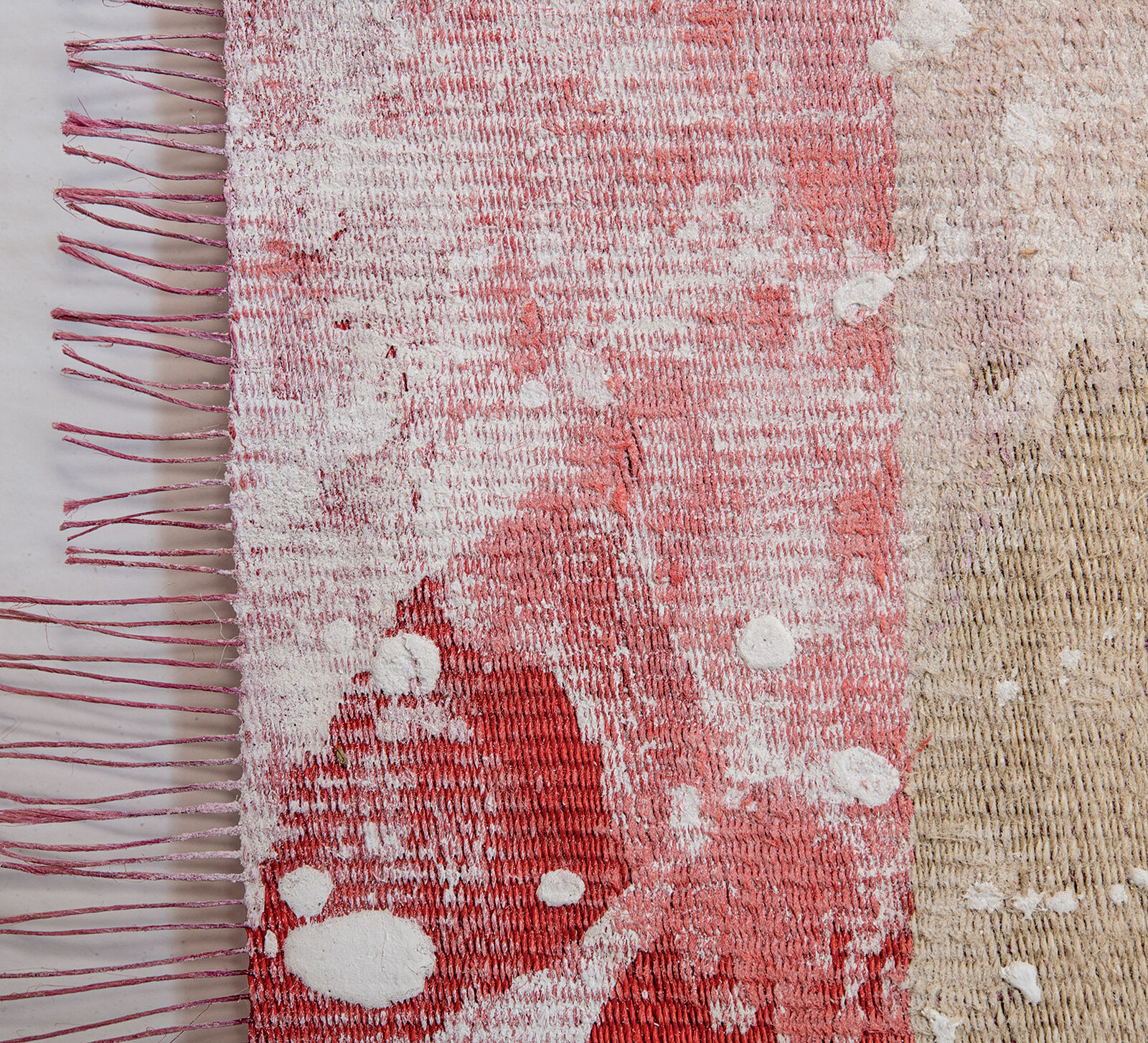 A framed textile artwork with vertical red and beige stripes hangs above a dark console table.