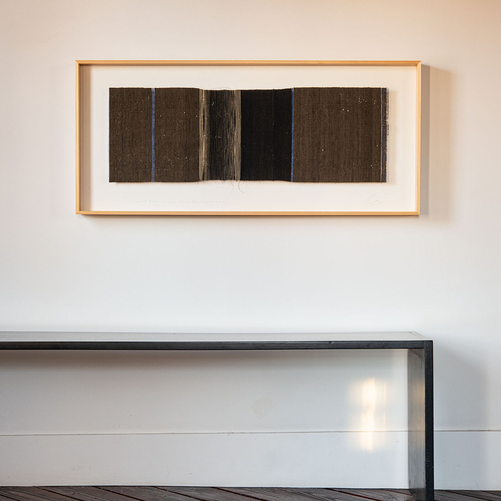 A picture hanging on a wall above a table.